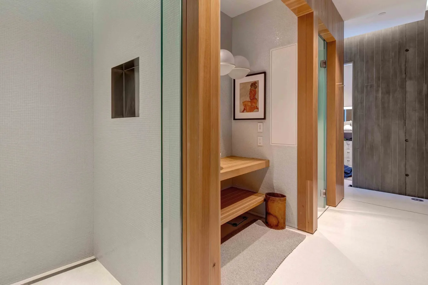 A bright hallway features a wooden bench and a framed picture.