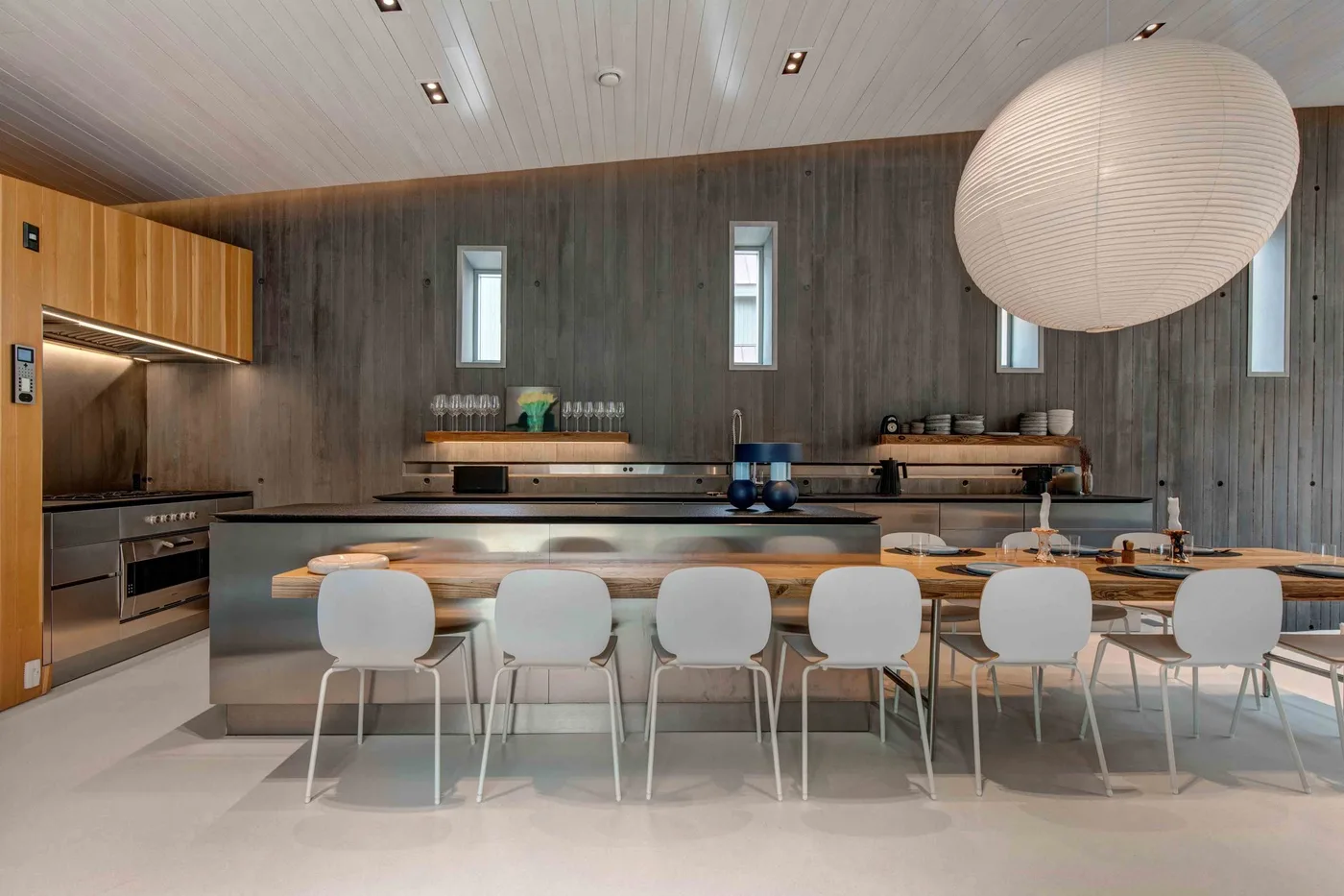 A spacious kitchen and dining area with a central island and dining table.
