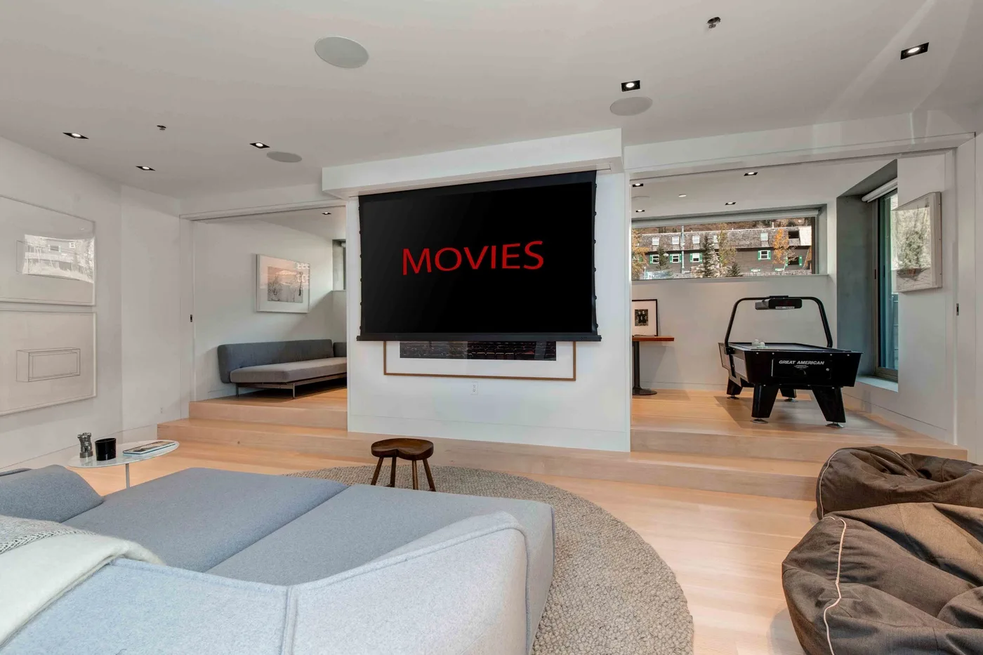 A modern living room with a large television and a seating area.