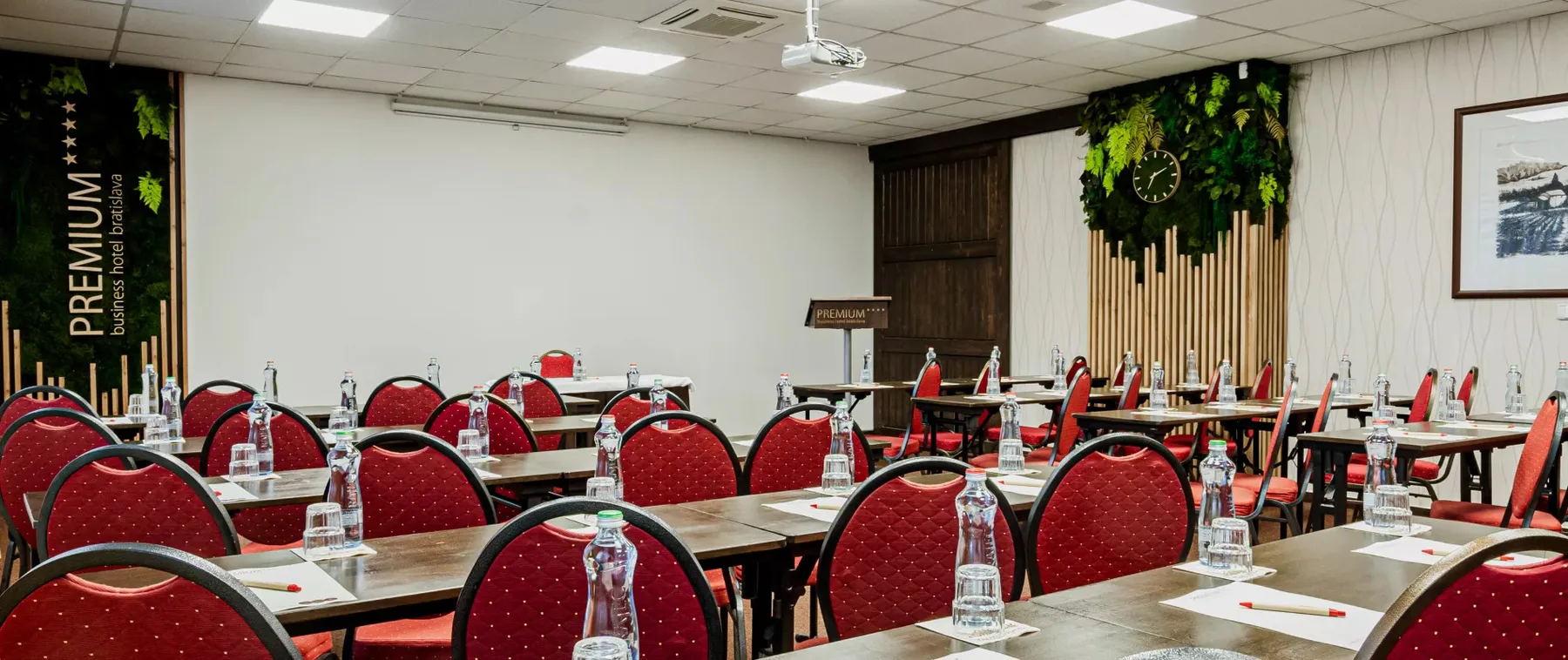 Sala de conferencias del hotel preparada para un seminario, con sillas rojas.