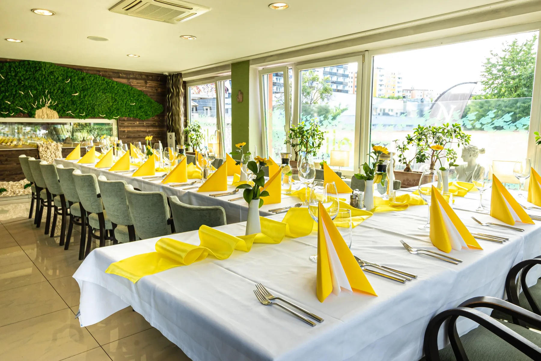 Hotel event room with a decorated table and green feature wall.