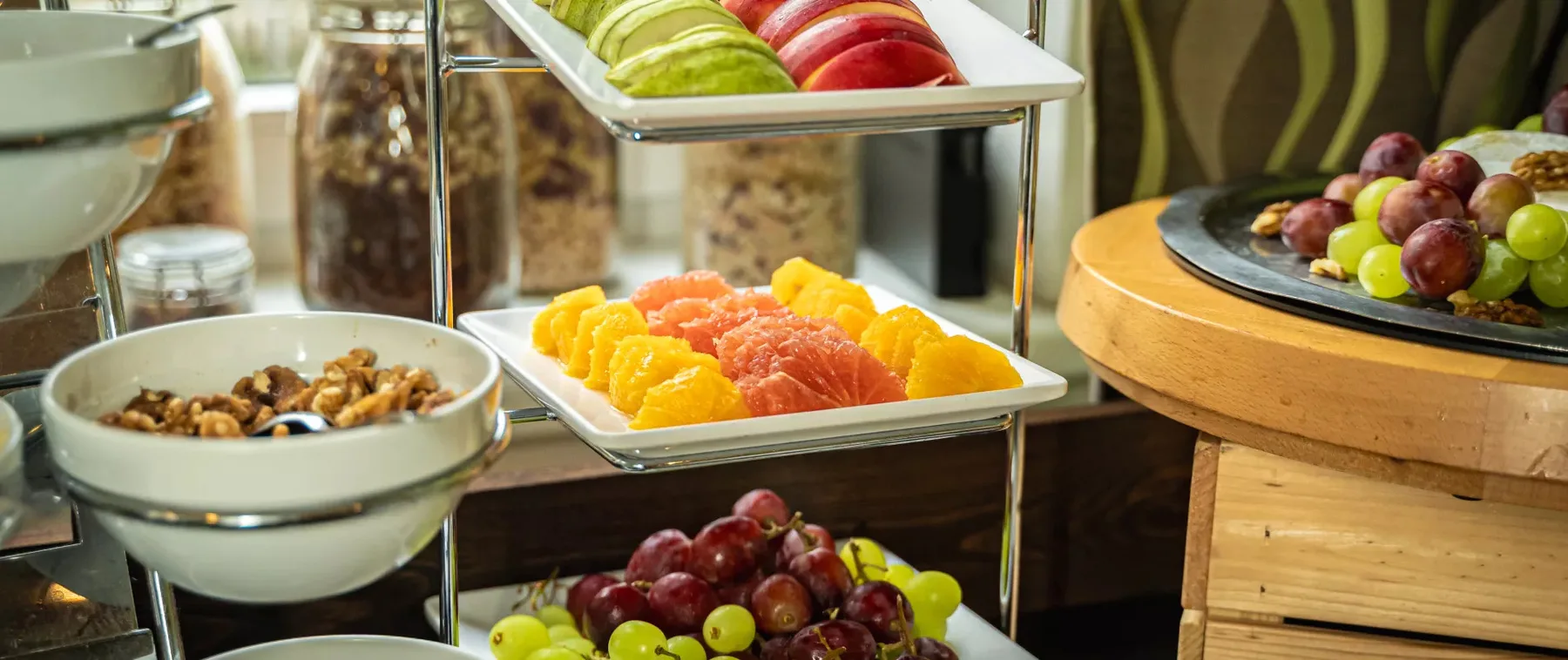 Breakfast buffet with fruit and bowls of nuts.