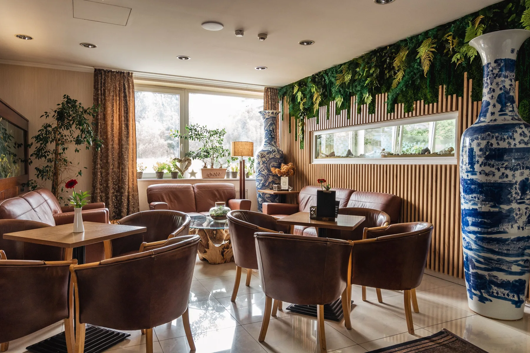 Lobby seating area with leather armchairs, large windows and wood detailing.