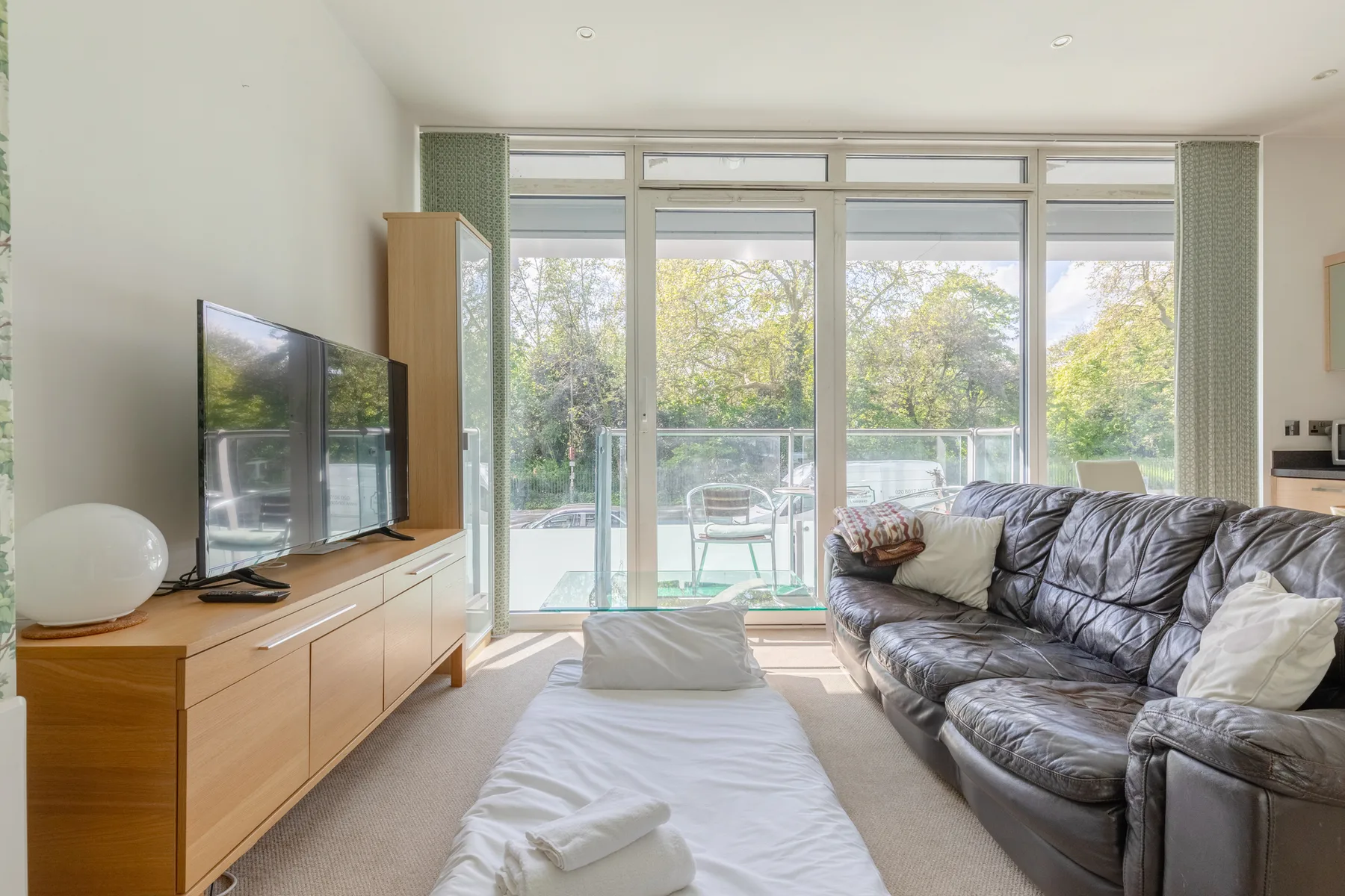 A living room with seating beside large windows overlooking trees.