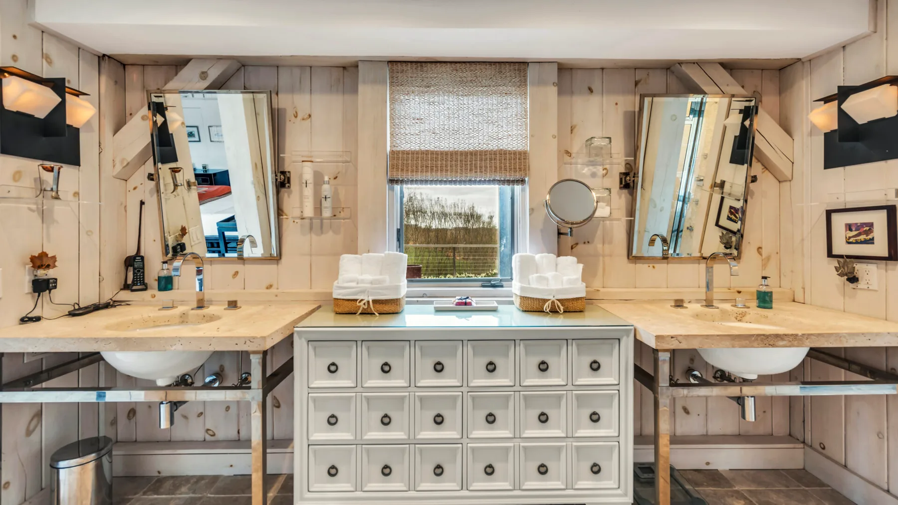 A bathroom vanity with two sinks and a central drawer cabinet.