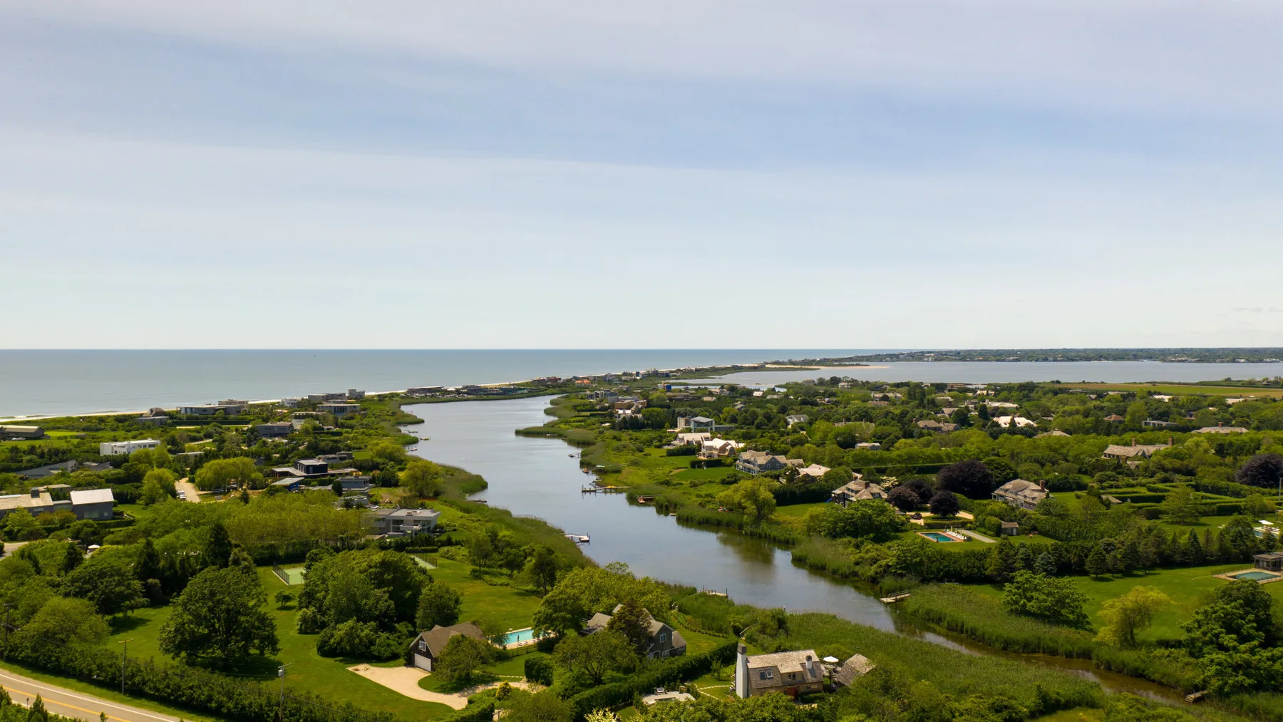 Aerial view of a river winding through green land with scattered homes.