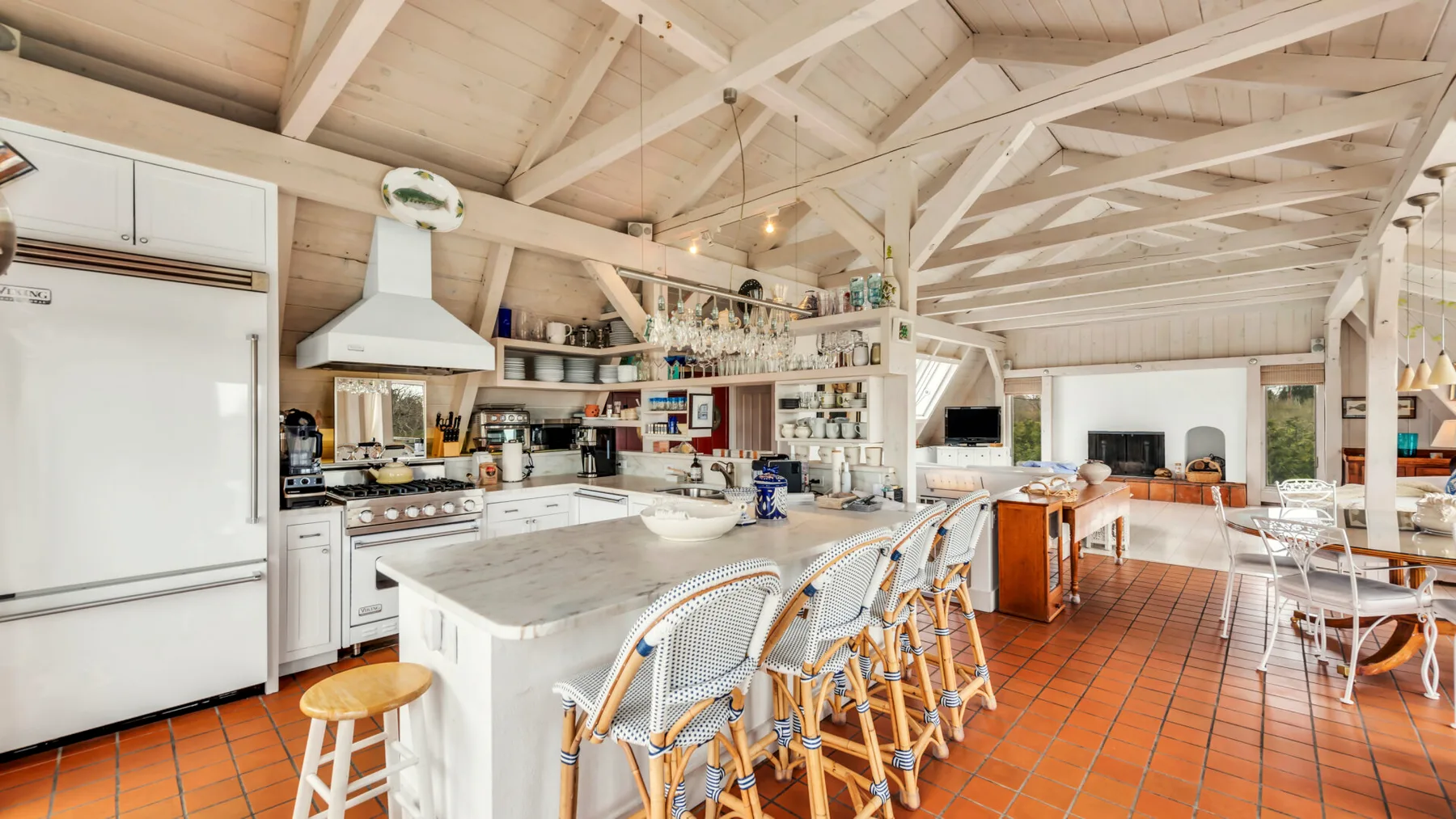 A spacious kitchen and dining area with a long counter and bar seating.