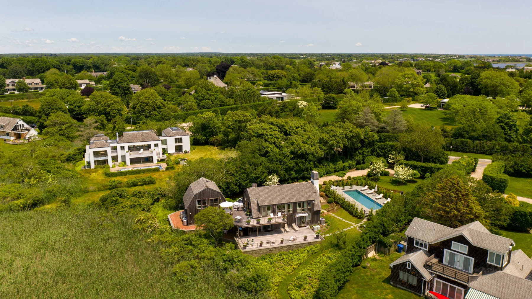 An aerial view of homes surrounded by green fields and trees.