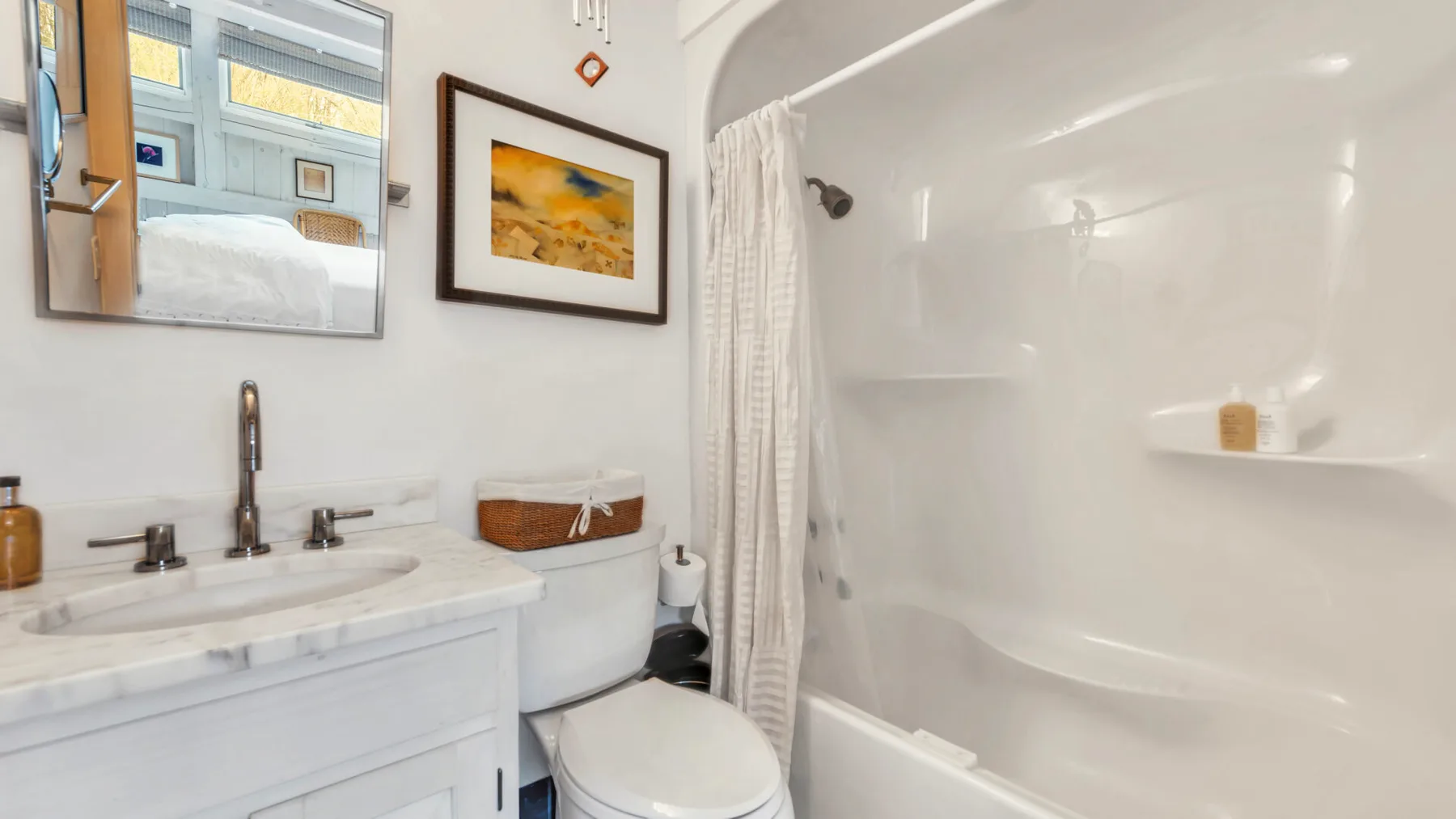 A bathroom with a sink, toilet, and shower.
