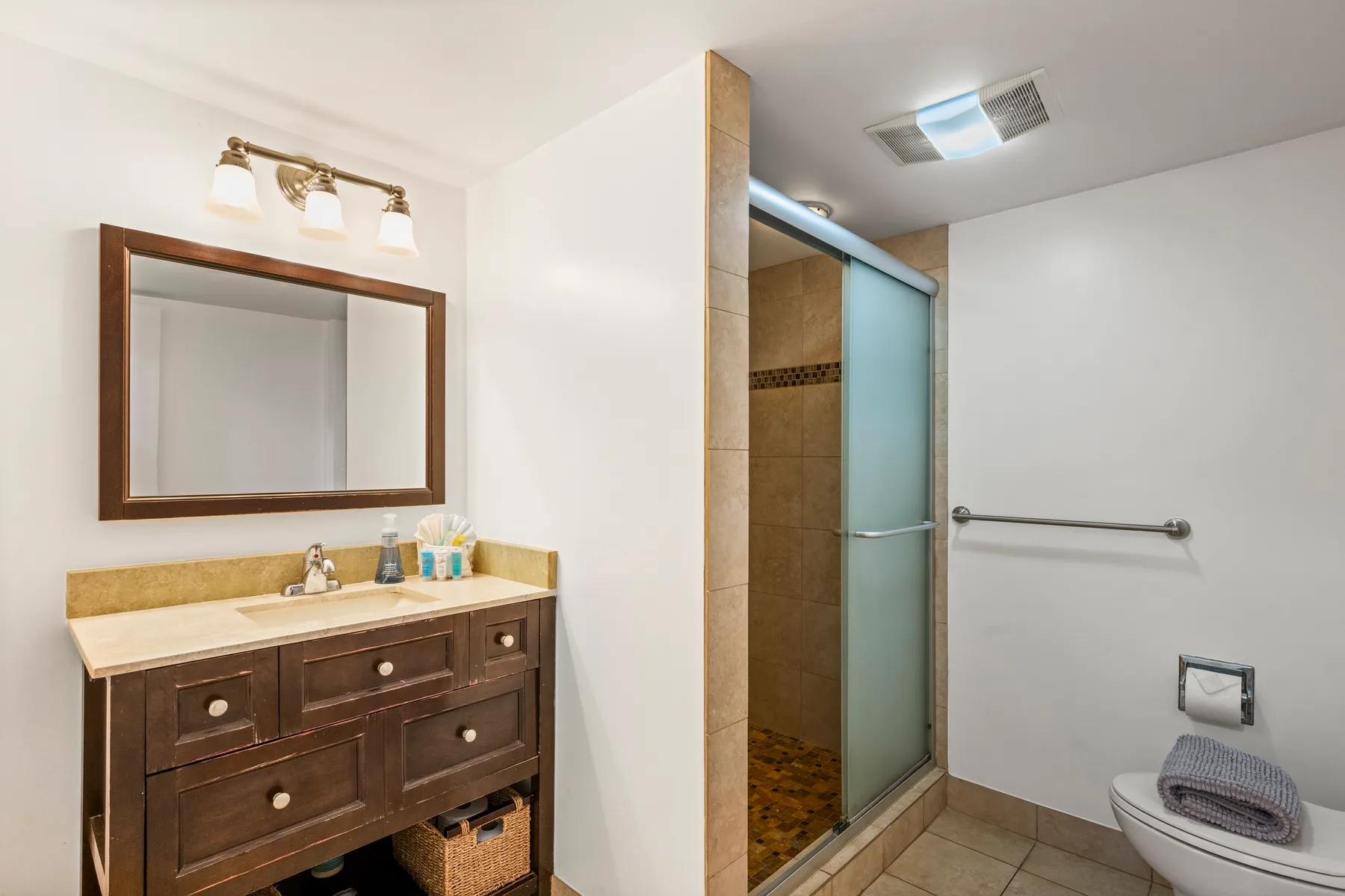 A bathroom with a vanity and a glass shower.