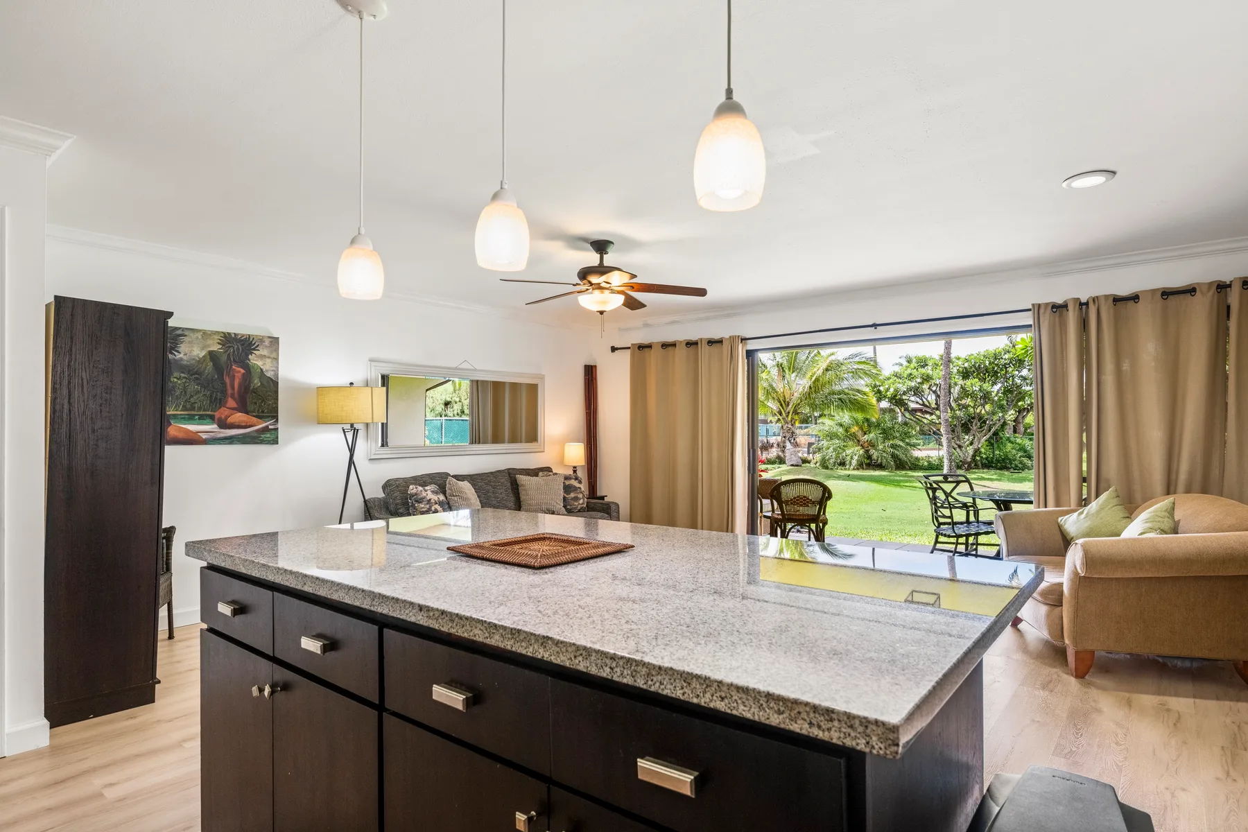 Open-plan living room with a kitchen island and sliding glass doors to a garden.