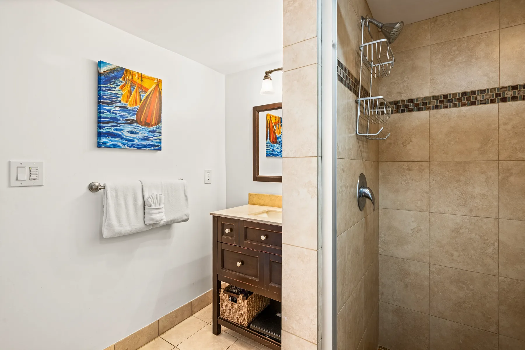 A bathroom with a tiled shower and a wooden vanity.