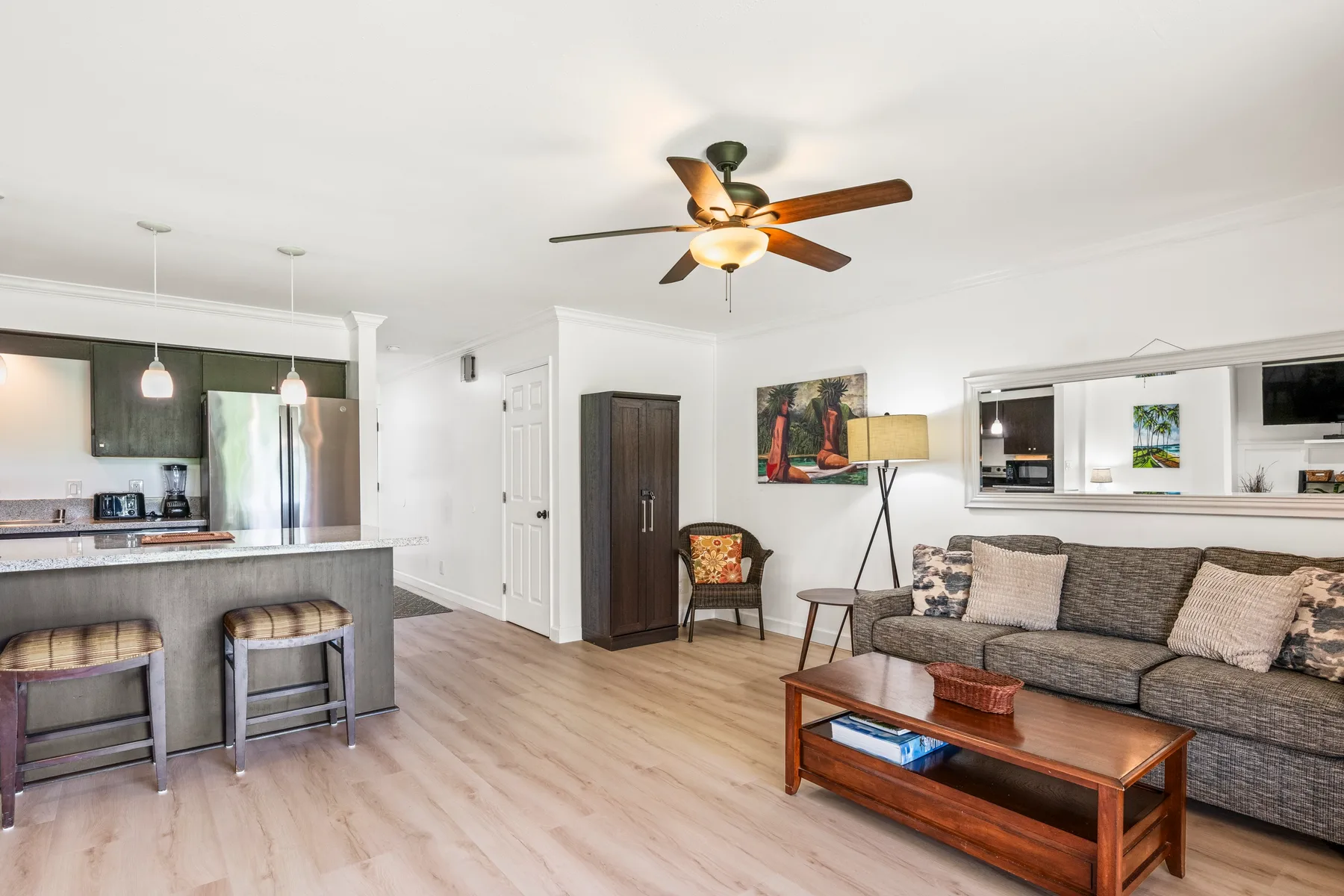 A bright open-plan living room with a kitchen island and seating area.