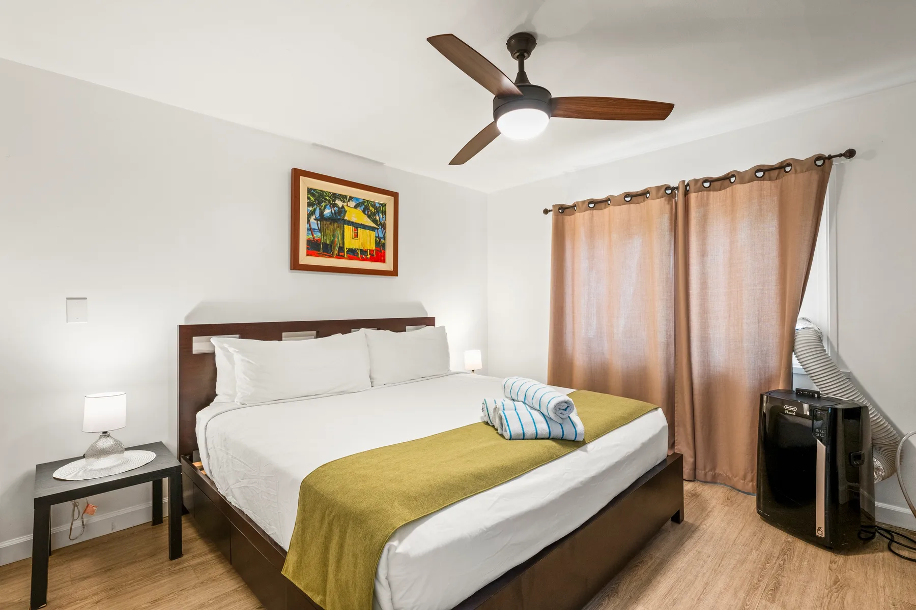 A bedroom with a neatly made bed and curtains covering the window.