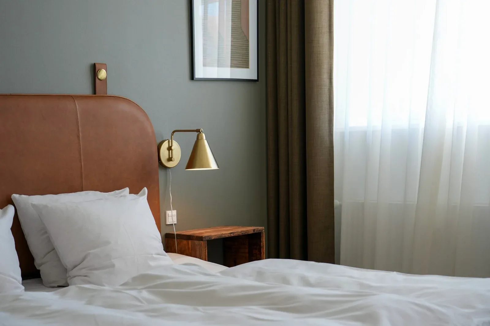 Modern bedroom with a leather headboard and wall lamp