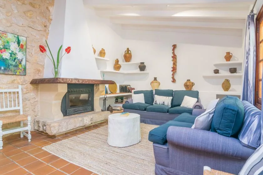 A living room with blue seating, a fireplace, and a round coffee table.