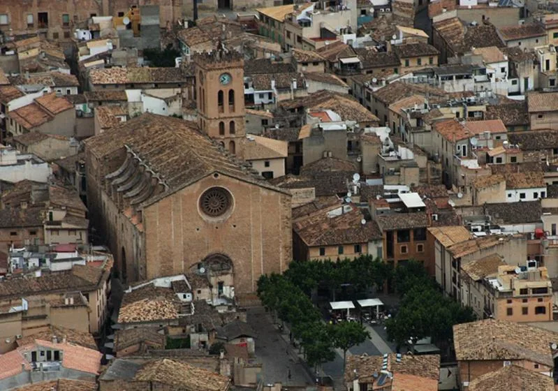 Aerial view of a historic town with a prominent church and closely packed buildings.