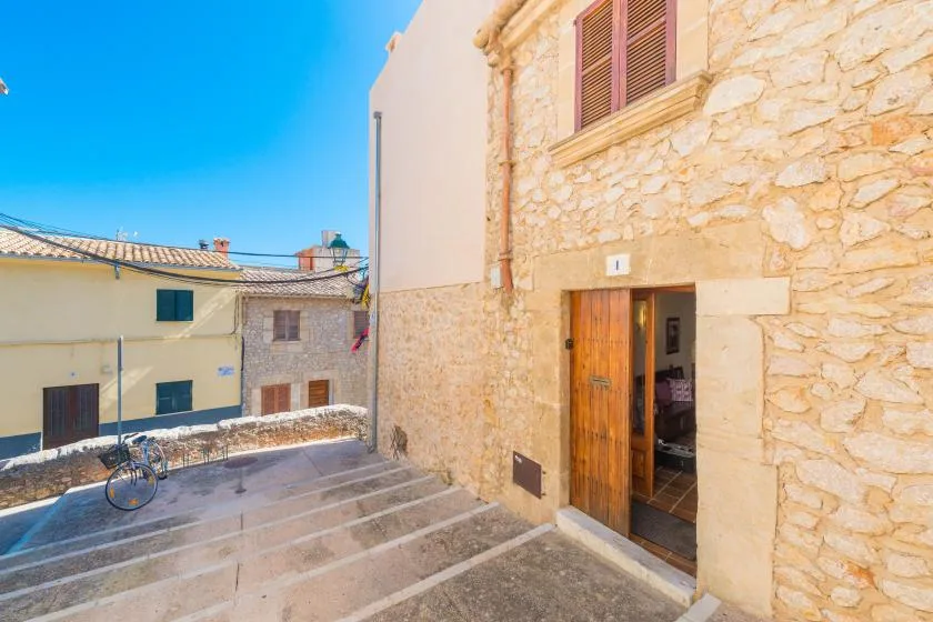 A stone building entrance opens onto a small paved courtyard.