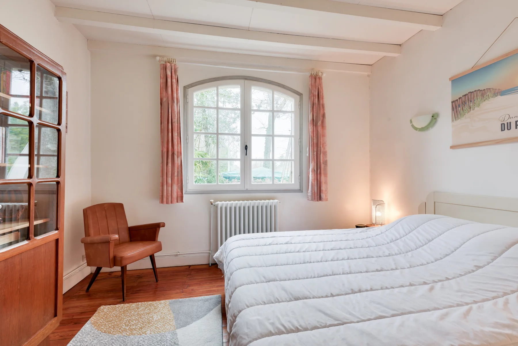 Bedroom with a large bed, window, and radiator.