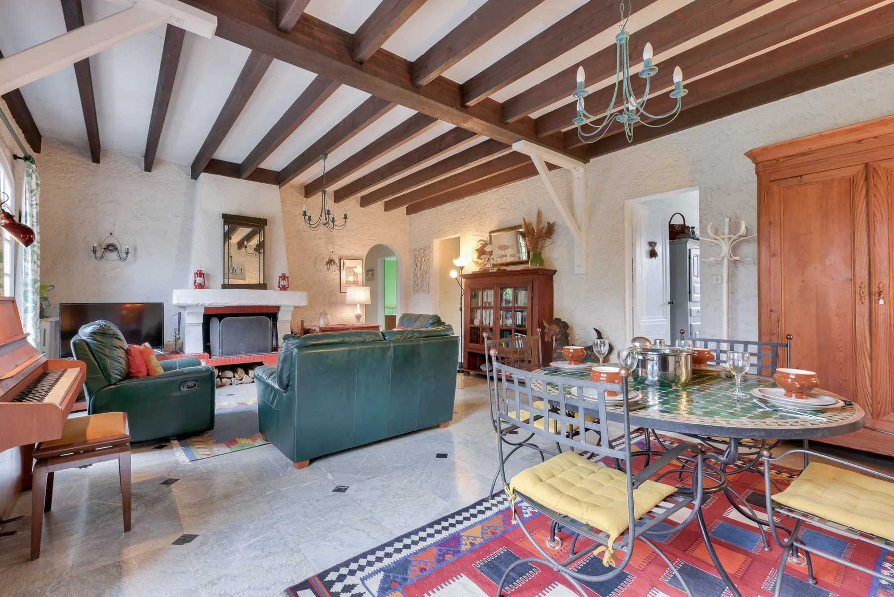 Living room with seating, a fireplace, and exposed ceiling beams.