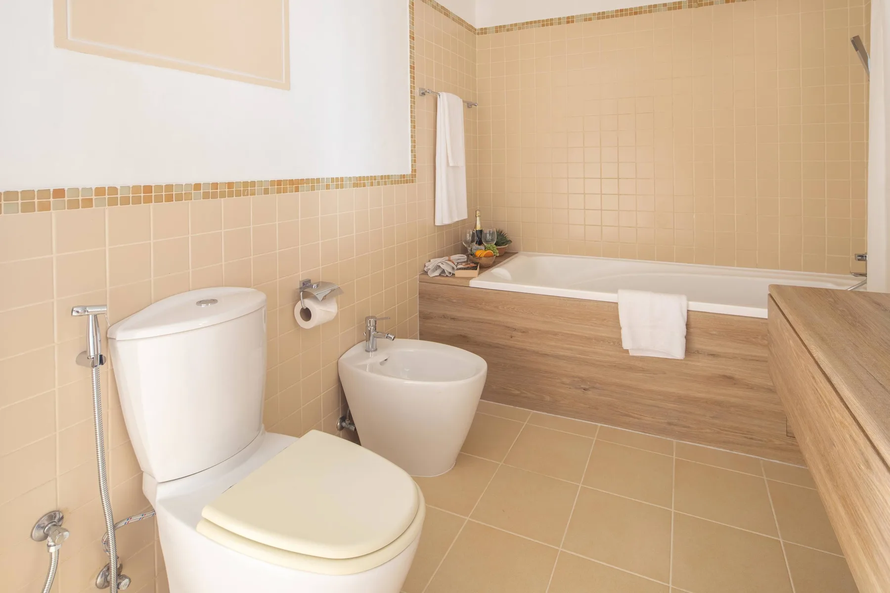 Un baño con azulejos, bañera, inodoro y bidé.