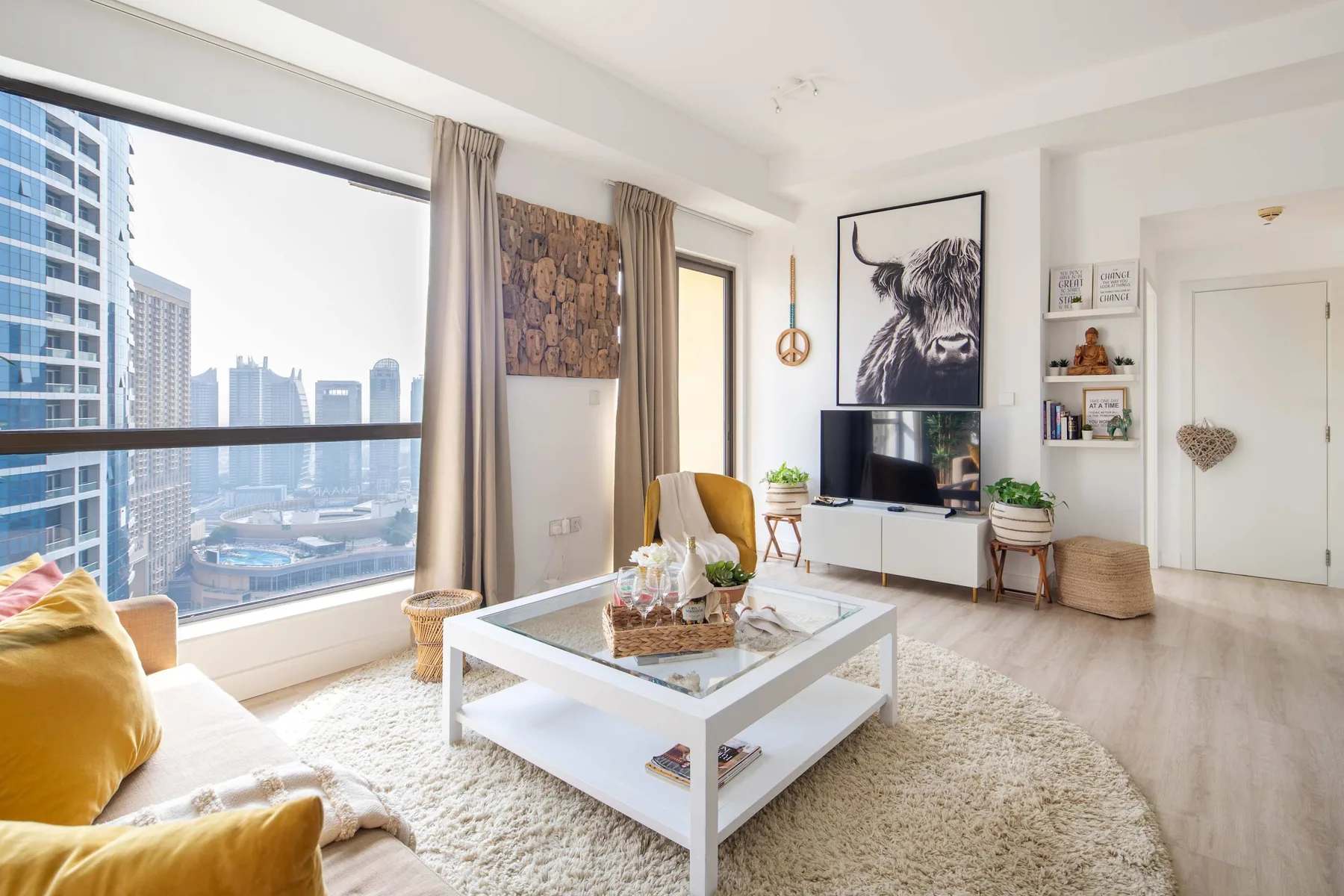 Una sala luminosa con una gran ventana que da a edificios cercanos de la ciudad.