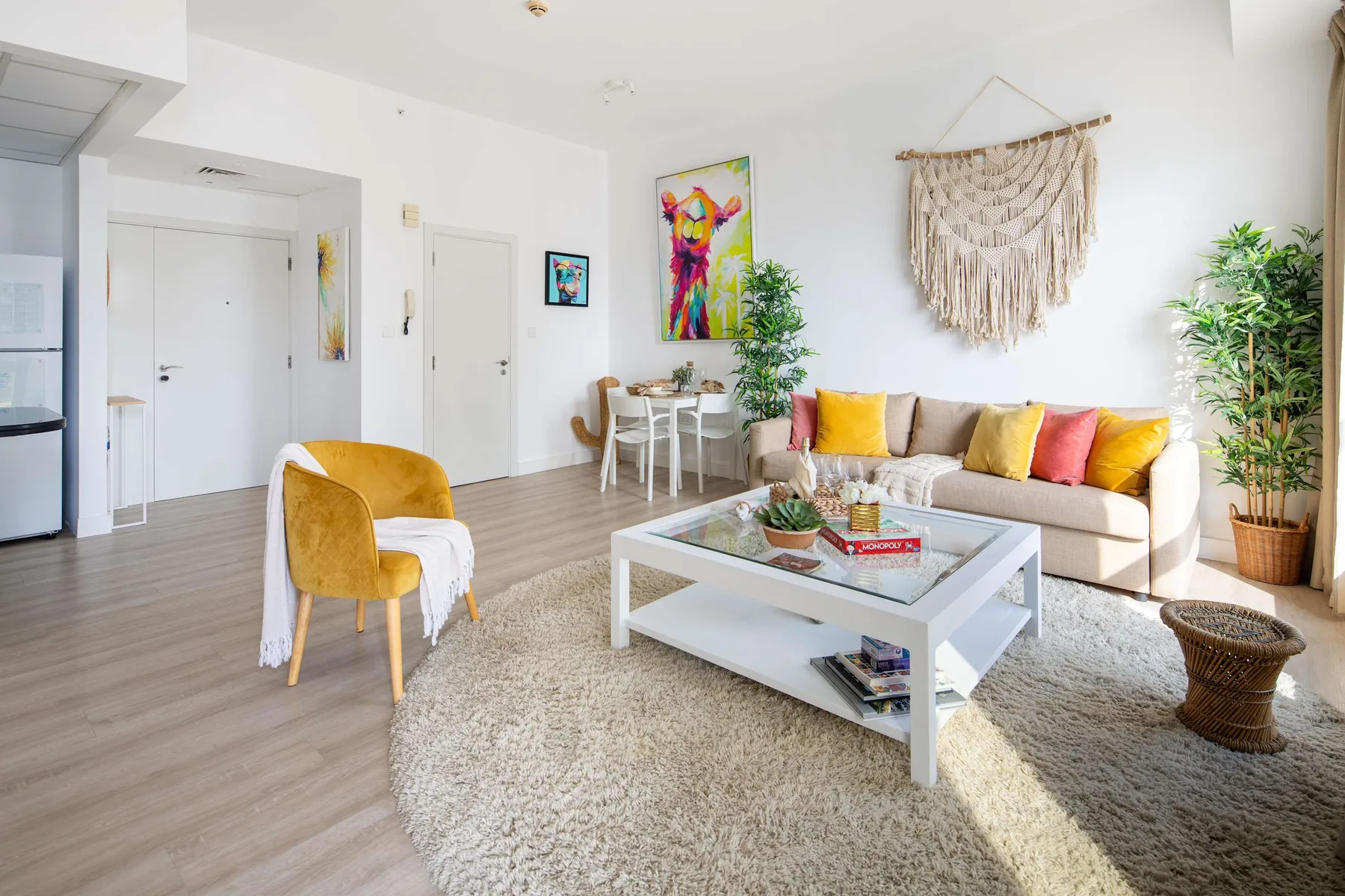 Una sala de estar luminosa con sofá, mesa de centro y cojines de colores.