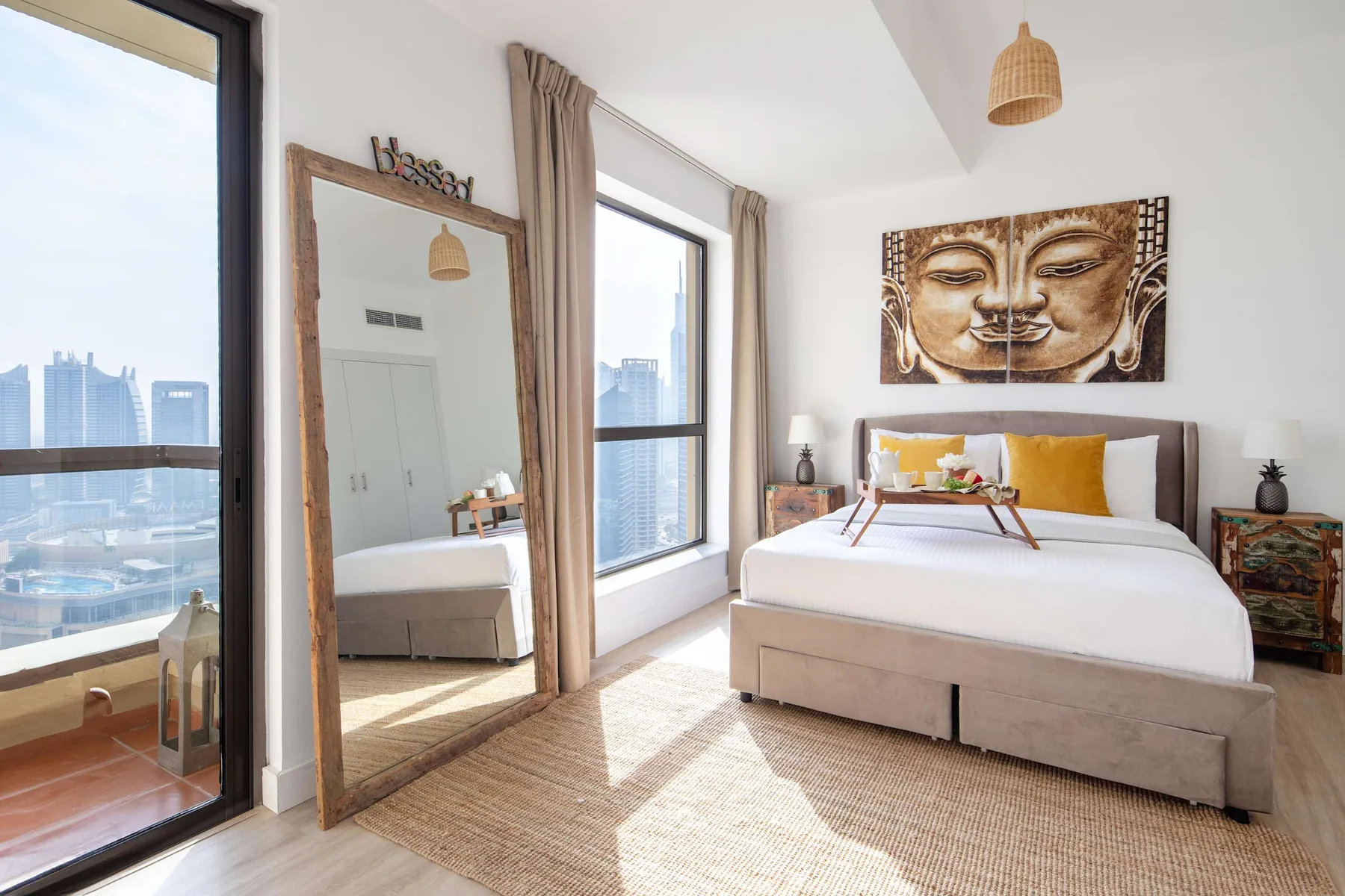Un dormitorio luminoso con una cama grande, ventanales y vistas a la ciudad.