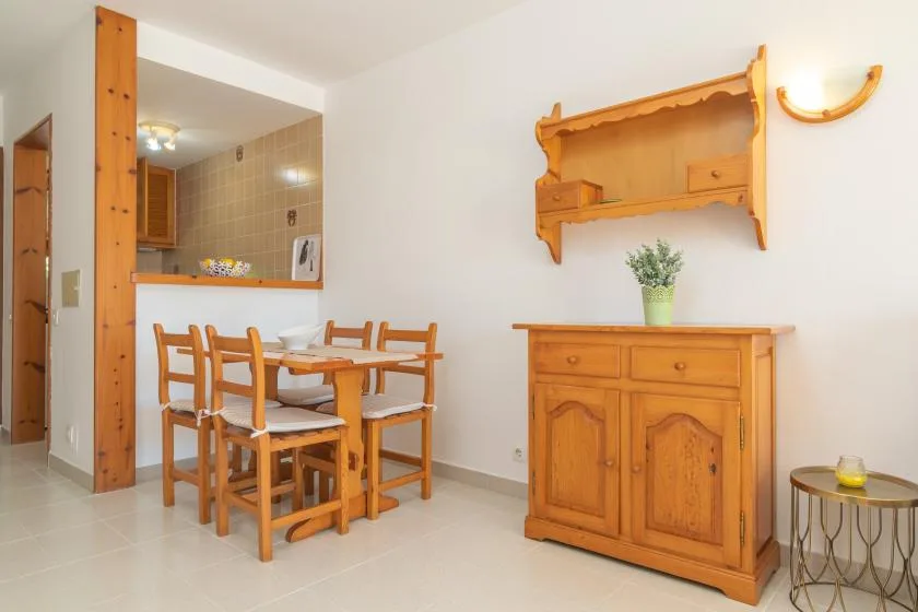 A dining area with a wooden table and chairs beside a matching sideboard.