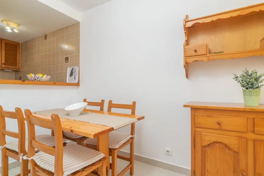 A dining area with a wooden table and chairs beside a wooden cabinet.