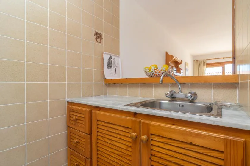 A bathroom vanity with a sink sits beneath a wall mirror.