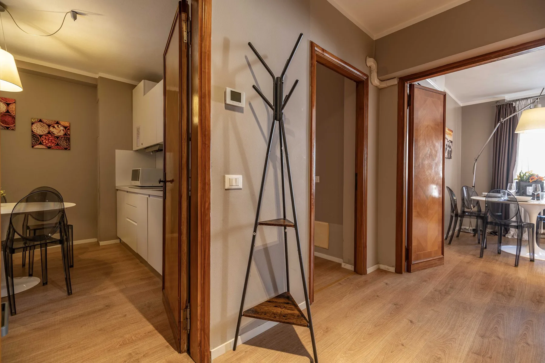 A furnished interior hallway opens onto a dining area and a compact kitchen.
