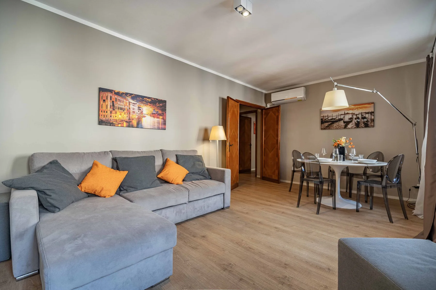 A living and dining area with a gray sectional and a table with chairs.
