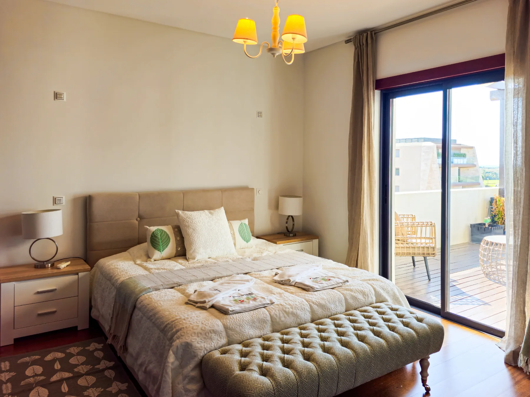 A bedroom with a double bed and sliding glass doors opening onto a balcony.