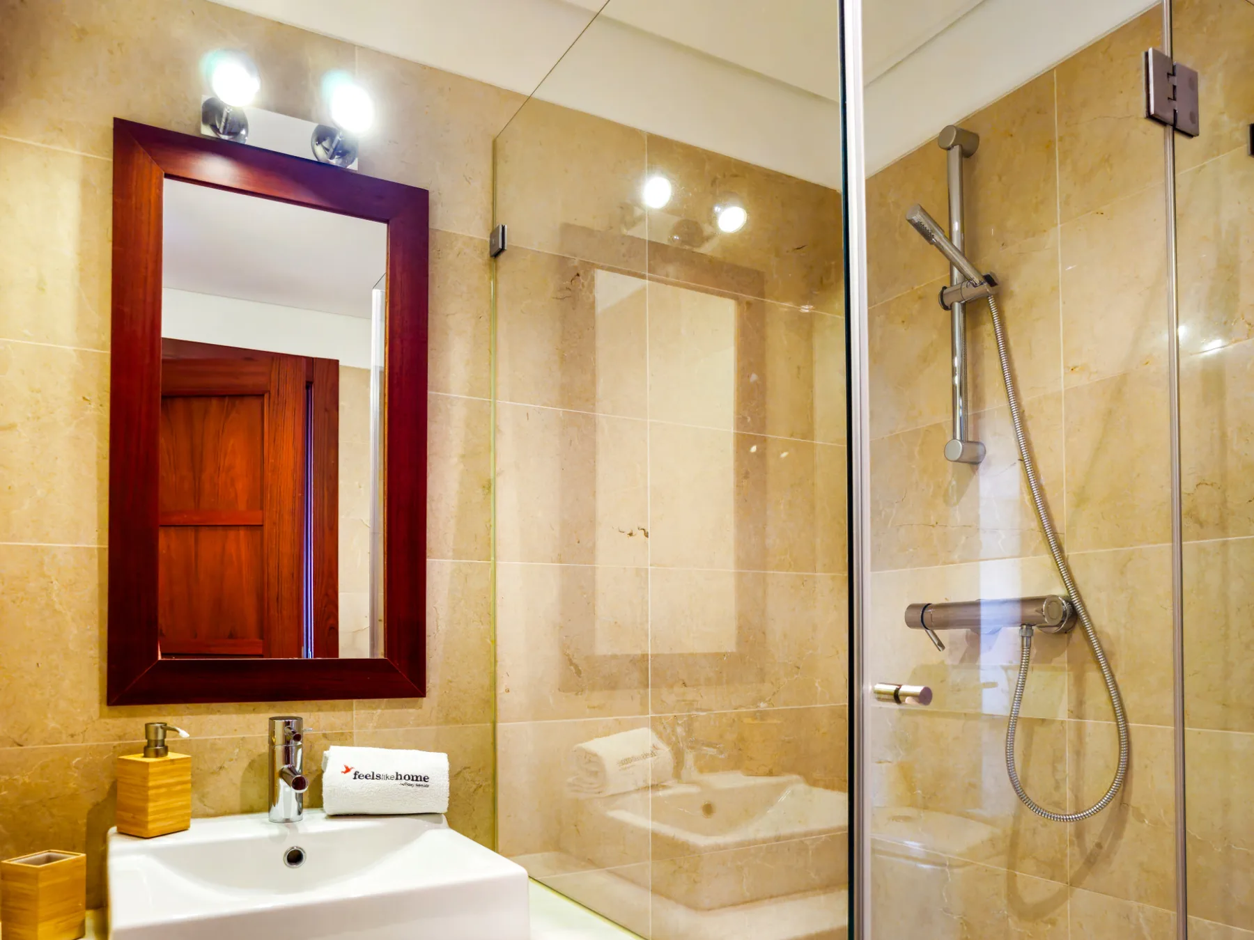 A bathroom with a sink, mirror, and glass shower.