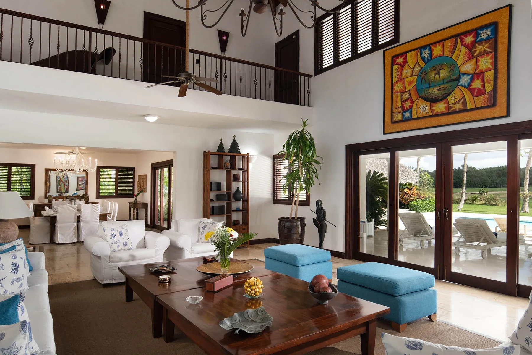 A spacious living room with seating, a coffee table, and glass doors opening onto a patio.