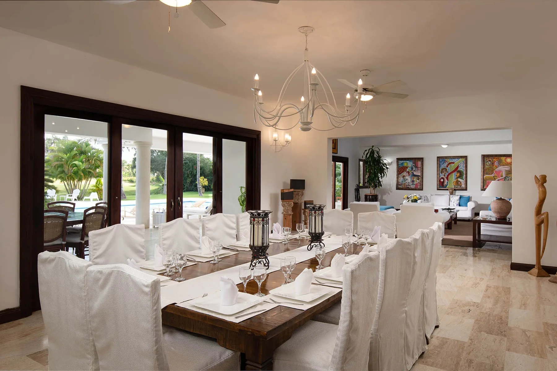 A dining area with a long table set beside large windows.