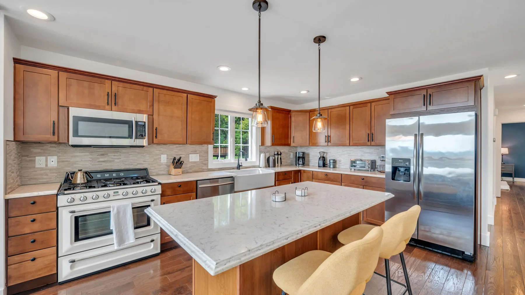 A spacious kitchen with wooden cabinets, a large island, and stainless steel appliances.