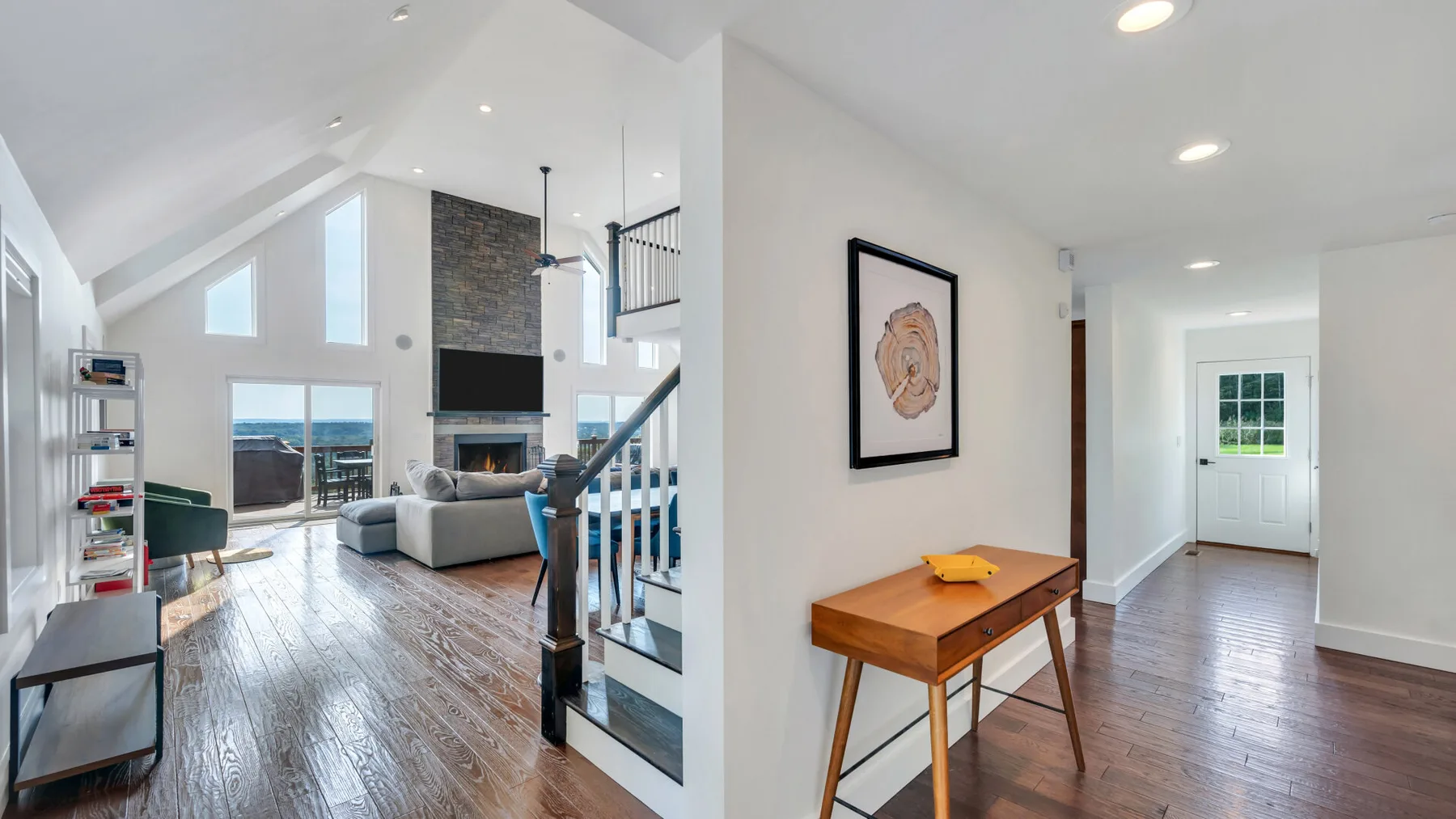 A bright open-plan living room with a dining table and staircase.