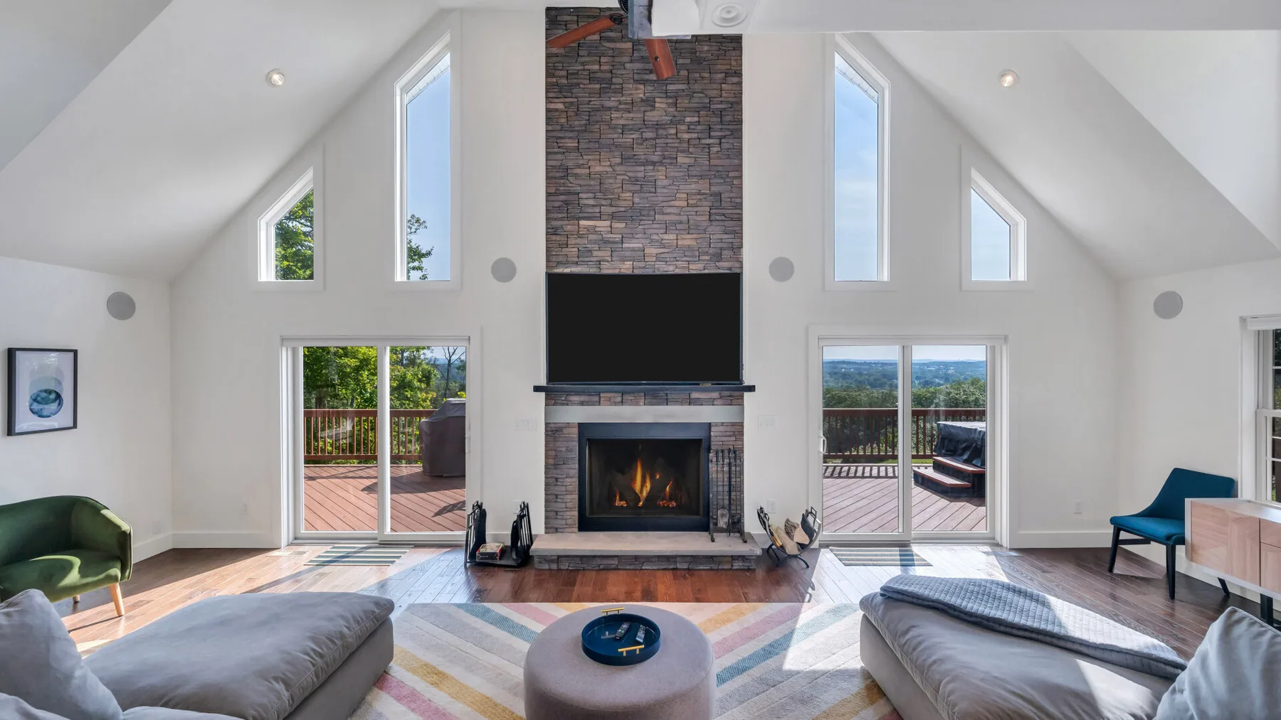 A bright living room with a fireplace, large windows, and seating.