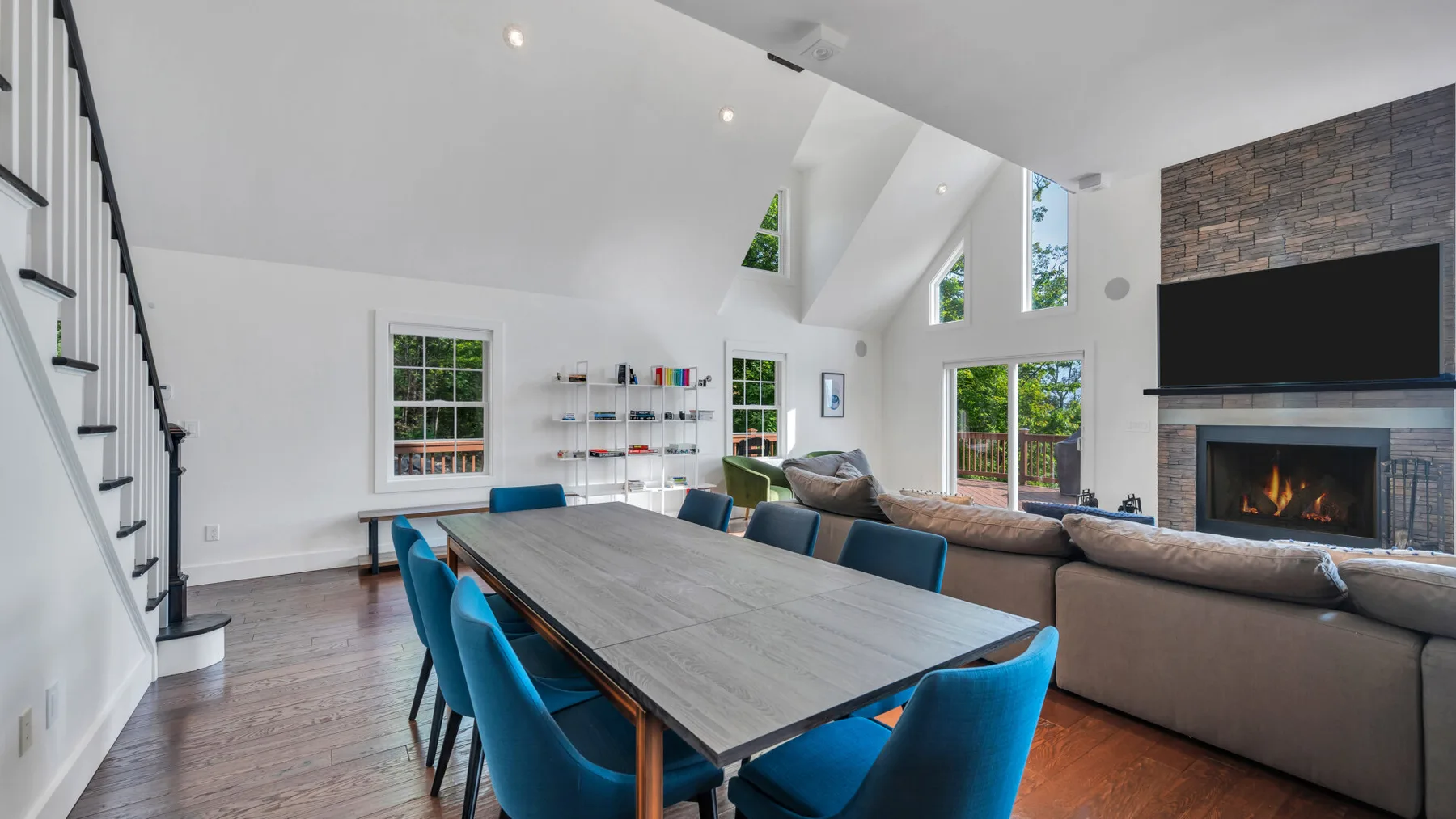 A bright open-plan living and dining room with a long table and seating.
