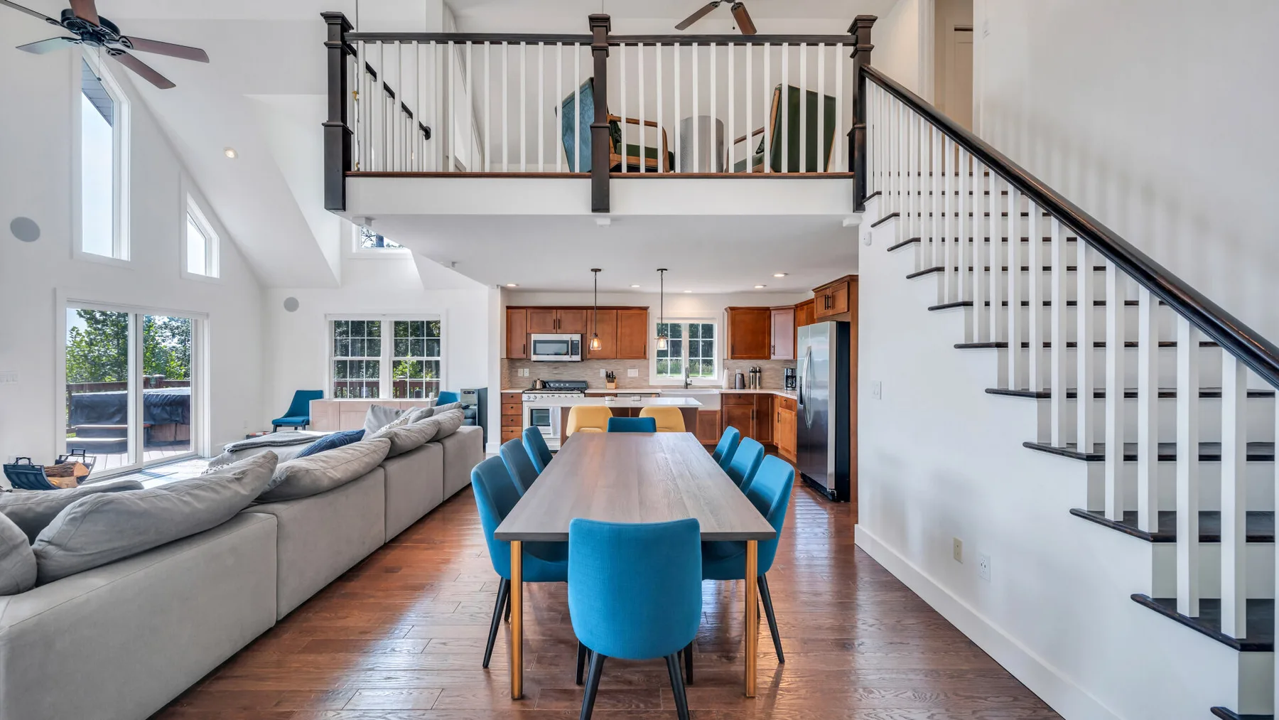A bright open-plan living and dining area with a kitchen and staircase.