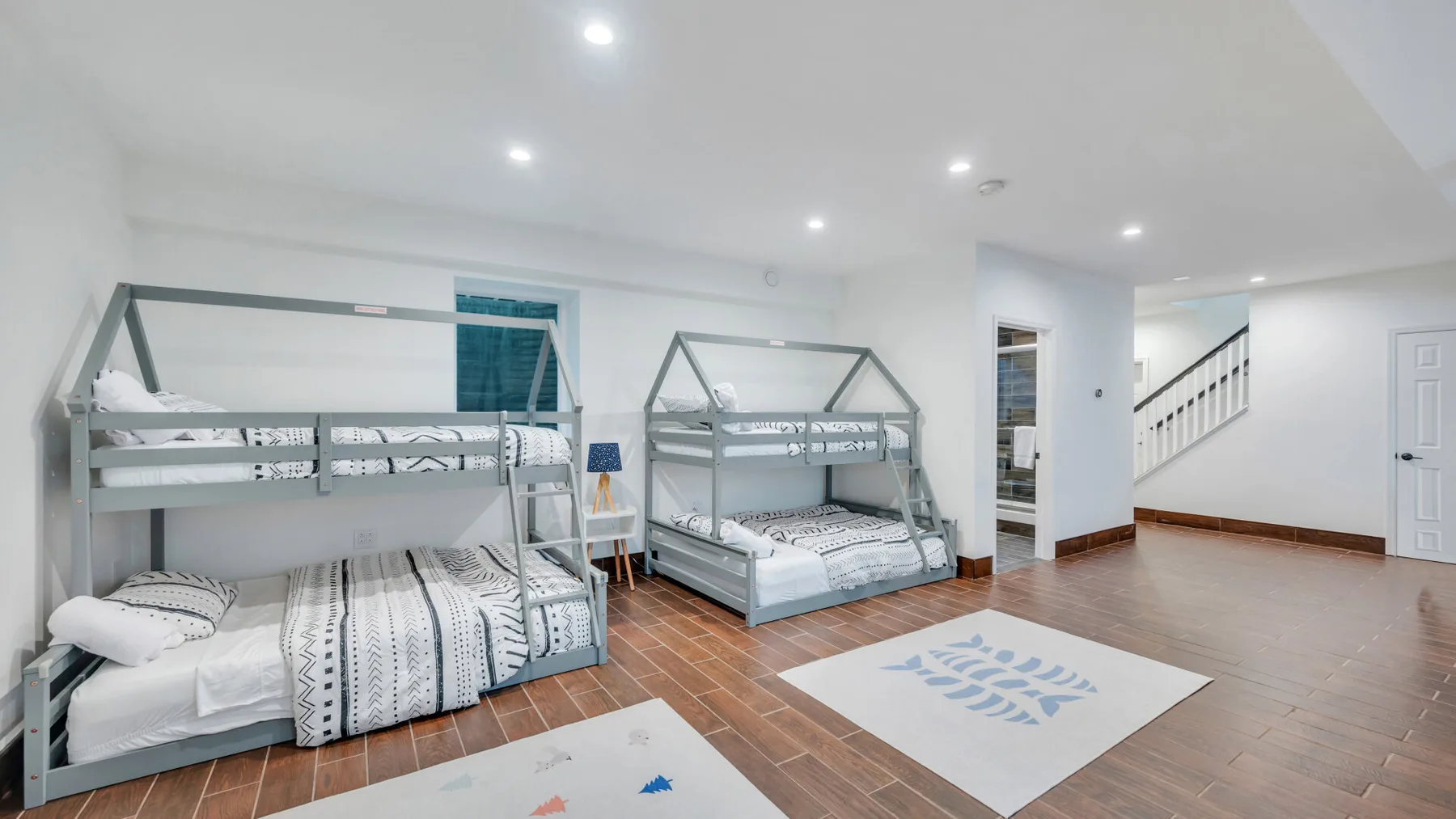A bright bedroom with two bunk beds and patterned bedding.