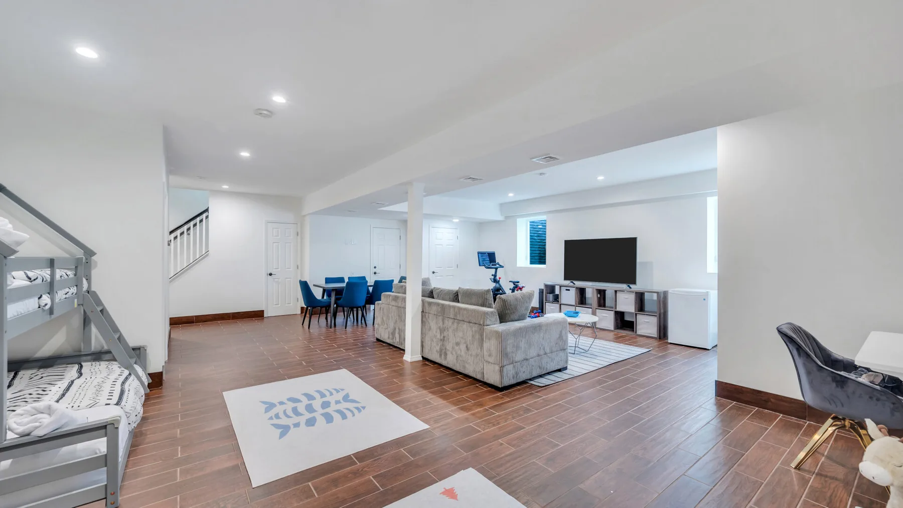 Open-plan living room with a seating area, dining table, and television.