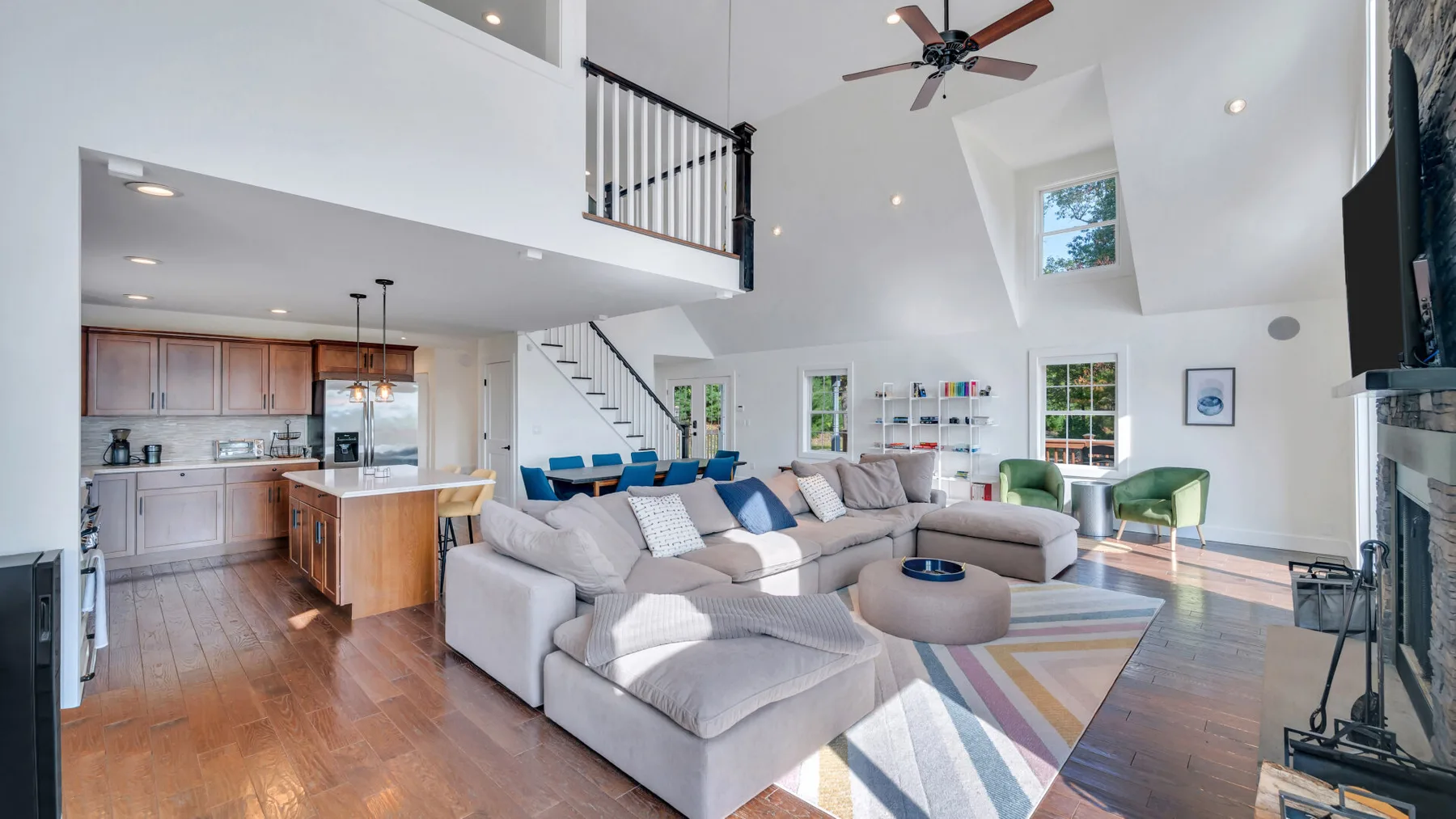 A bright open-plan living room and kitchen with a large sectional seating area.