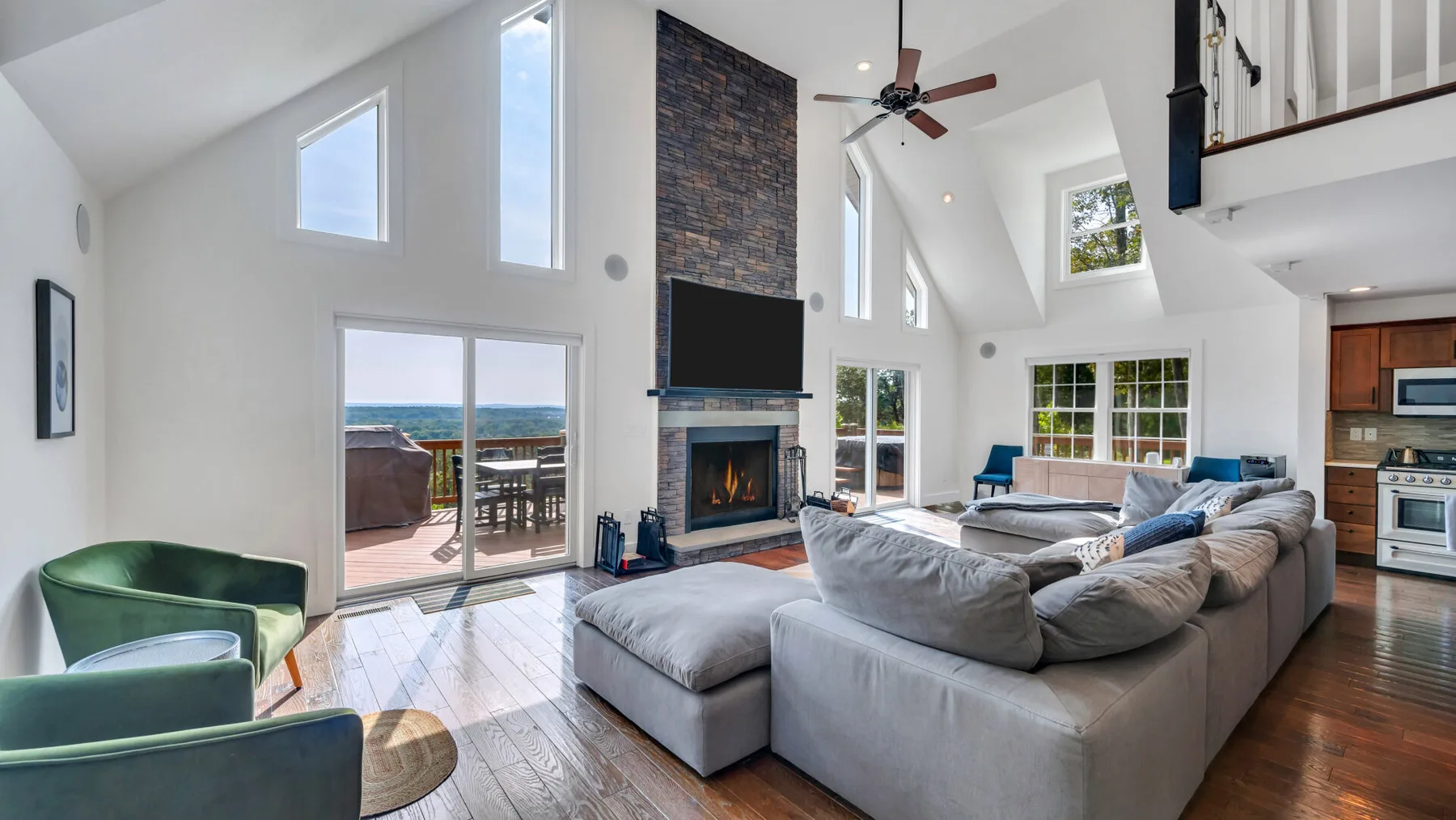 A bright living room with a large sectional sofa and tall windows.