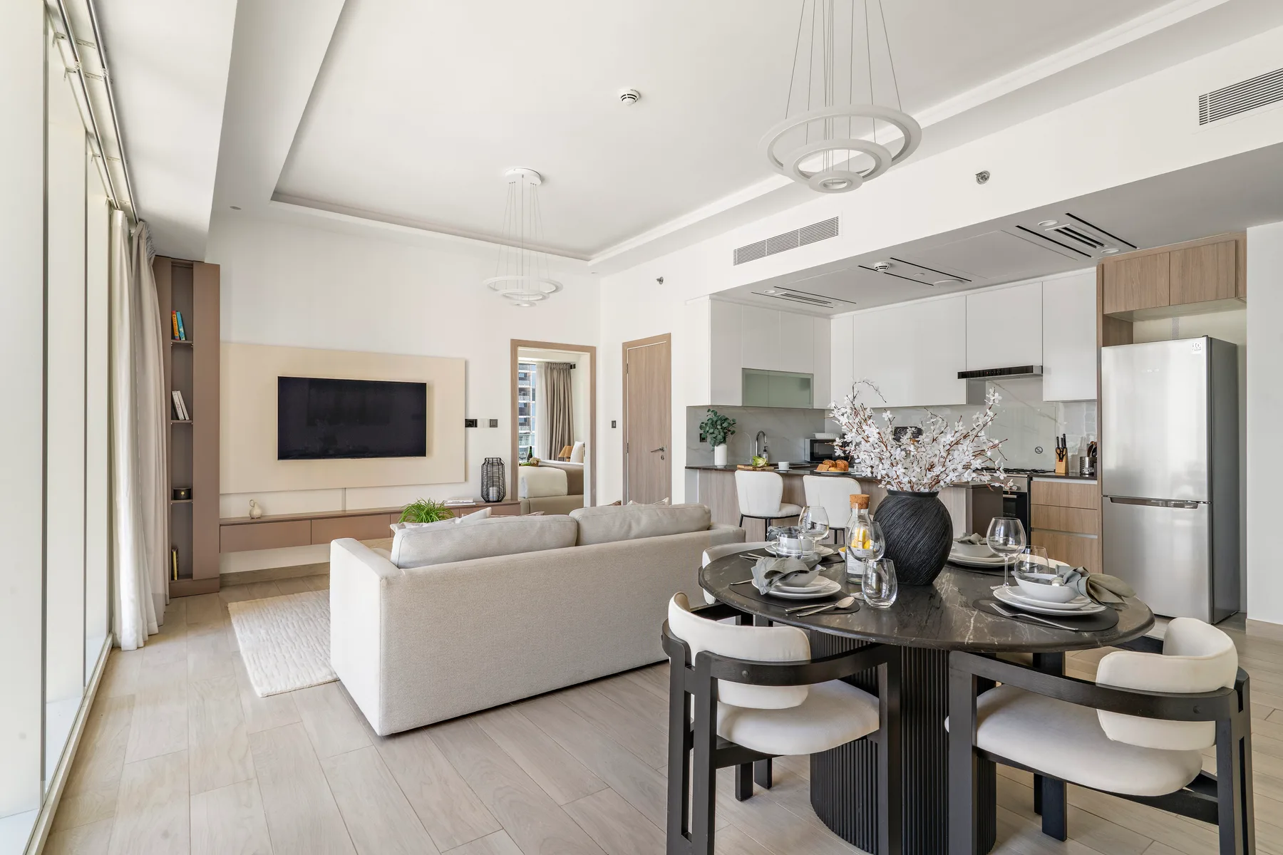 Una sala-comedor de planta abierta con un televisor y una mesa puesta.