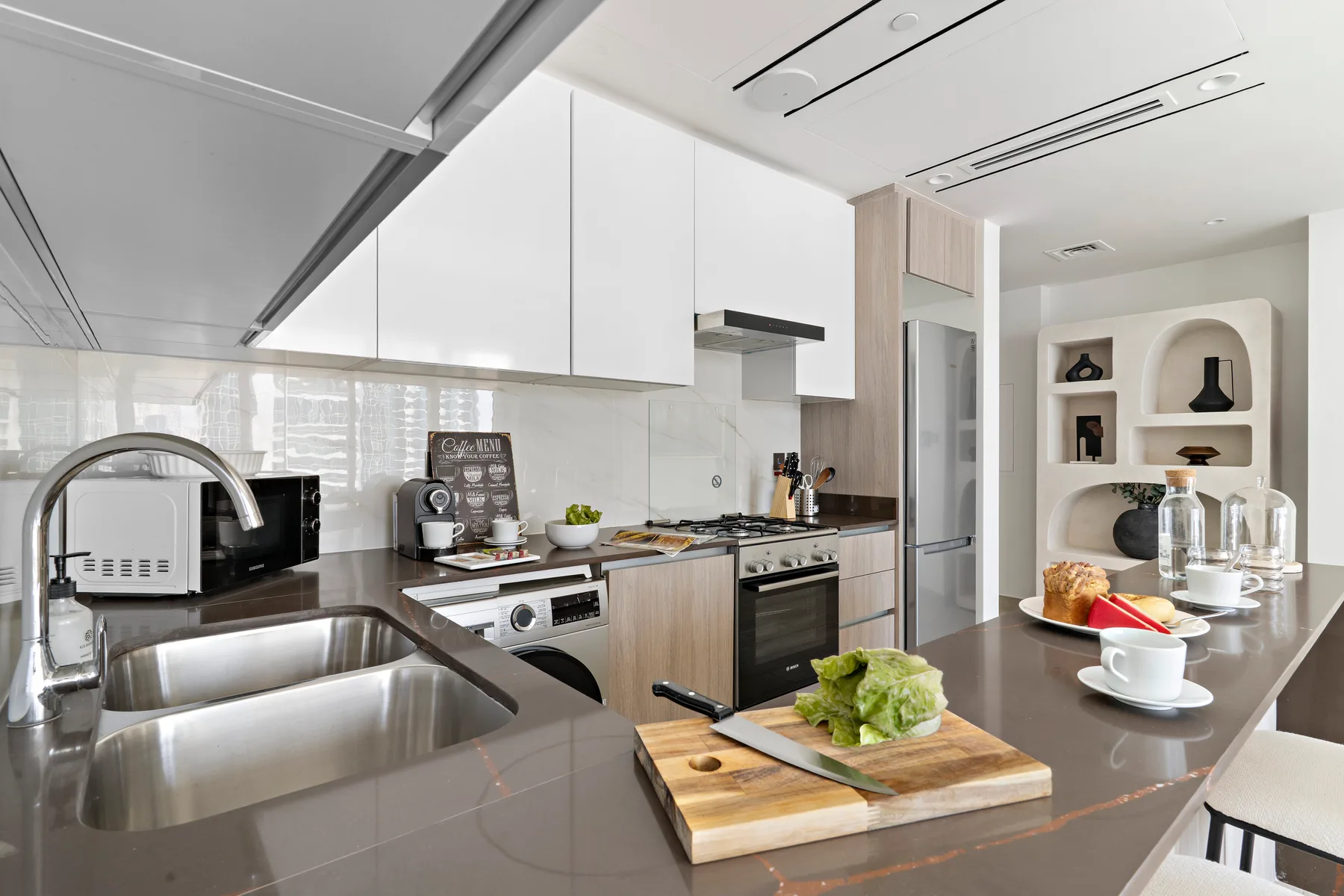 Una cocina moderna con una isla amplia, fregadero y asientos junto a la encimera.
