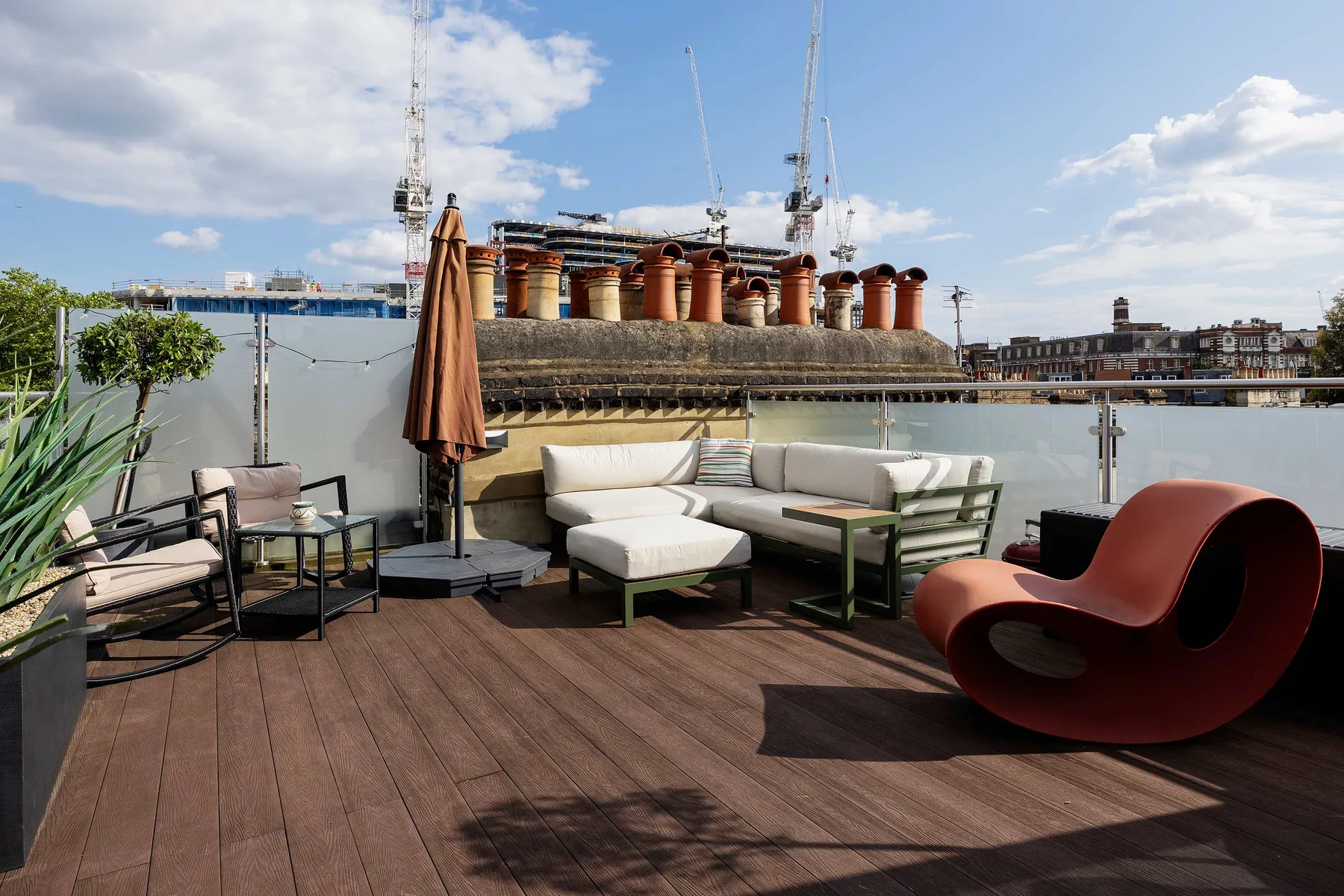 Una terraza en la azotea tiene asientos al aire libre y vistas de edificios cercanos.