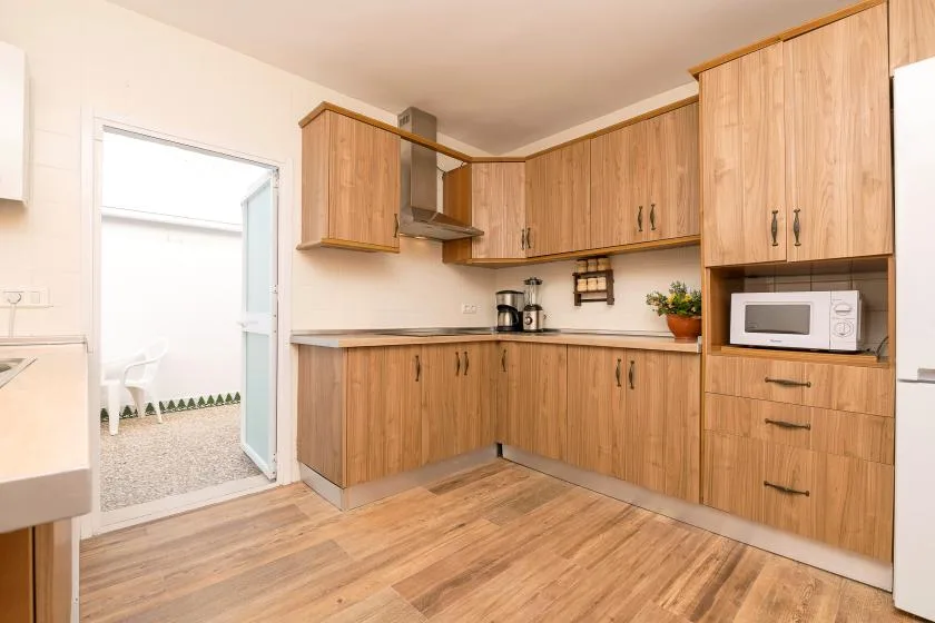 A kitchen with wood-tone cabinets, countertops, and a microwave.